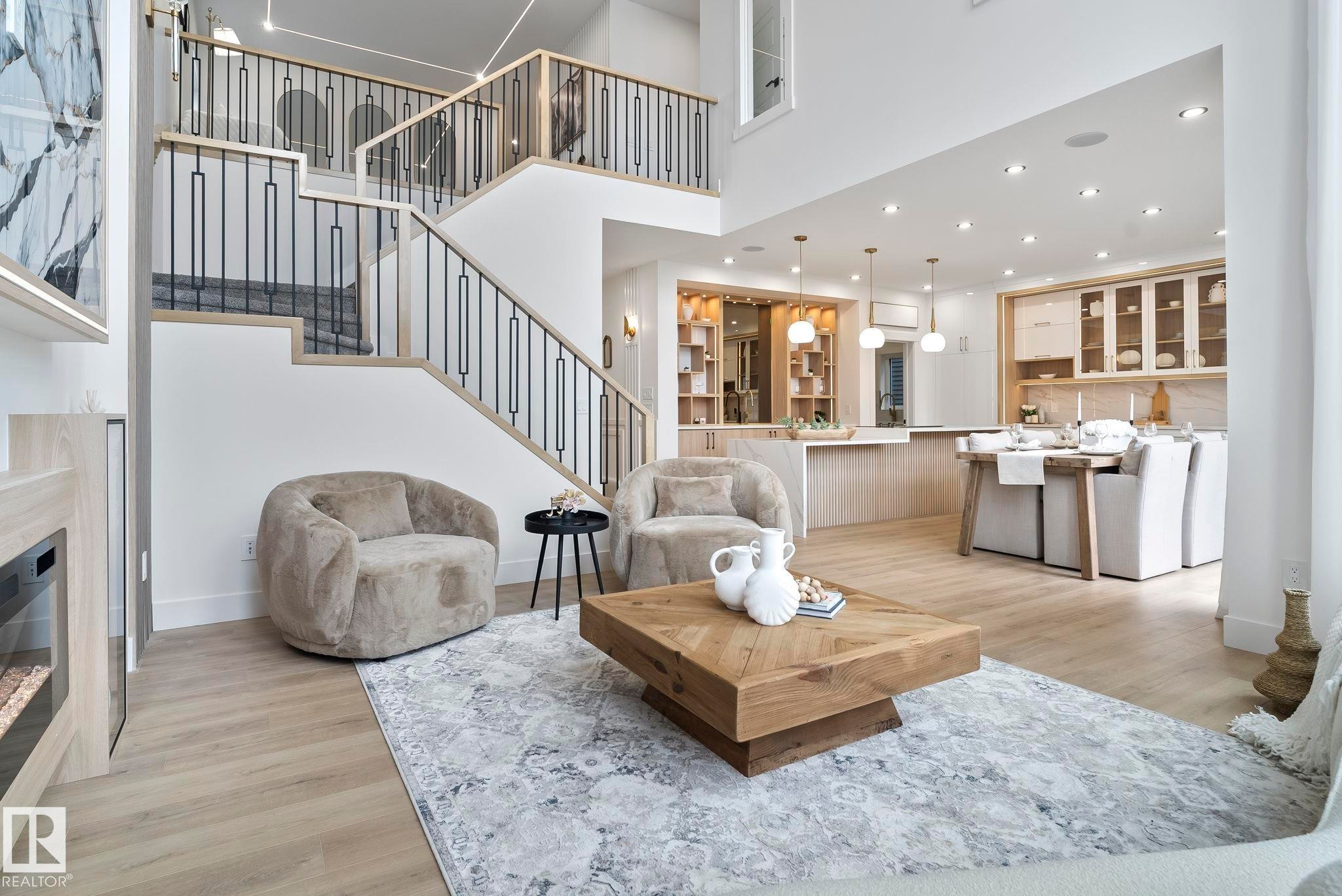 Open-concept living area with high ceilings, wood-finish flooring, and a modern fireplace feature - 13152 187 Avenue, Edmonton, AB