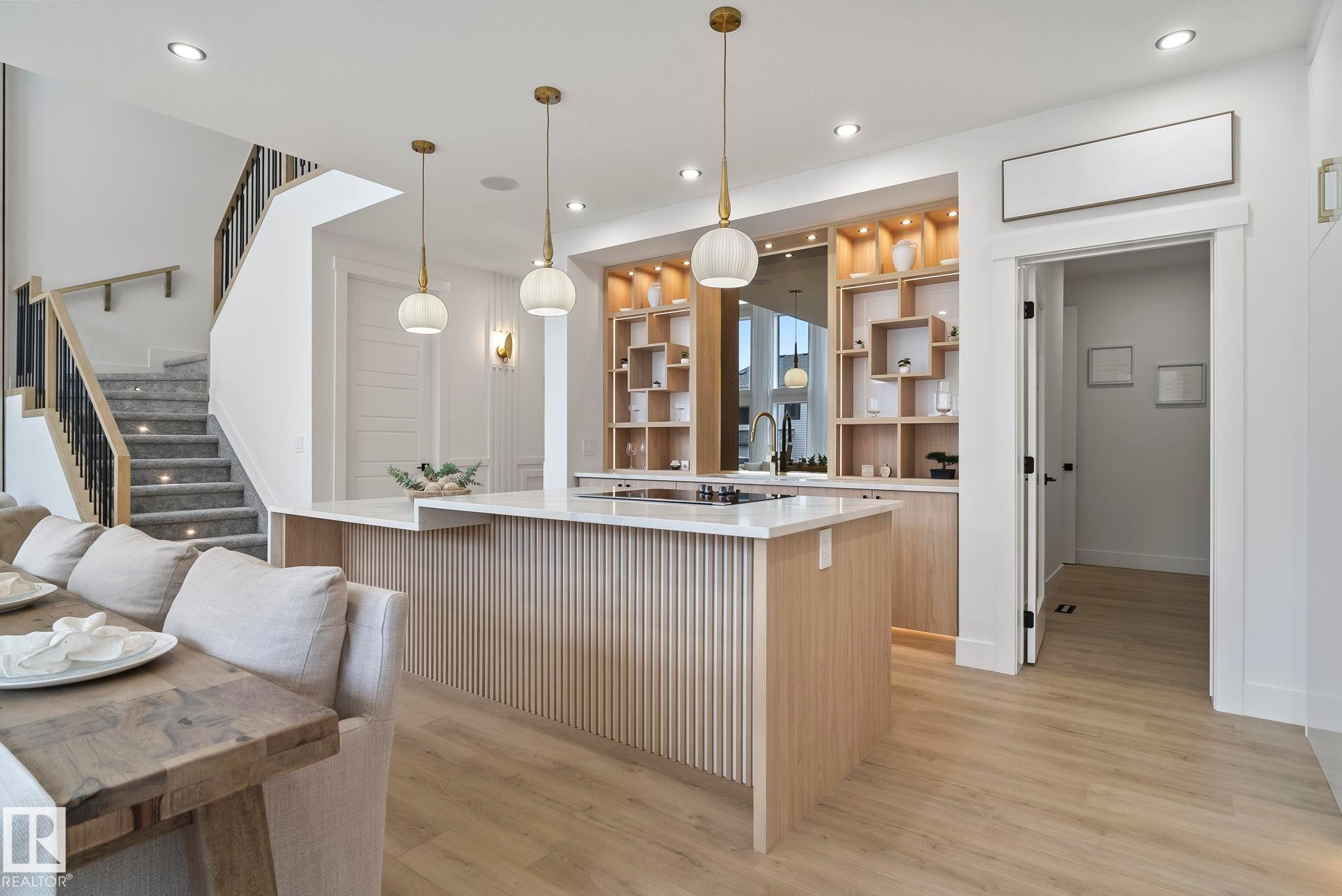 Open-concept kitchen with an expansive island featuring a fluted wood-finish panel - 13152 187 Avenue, Edmonton, AB