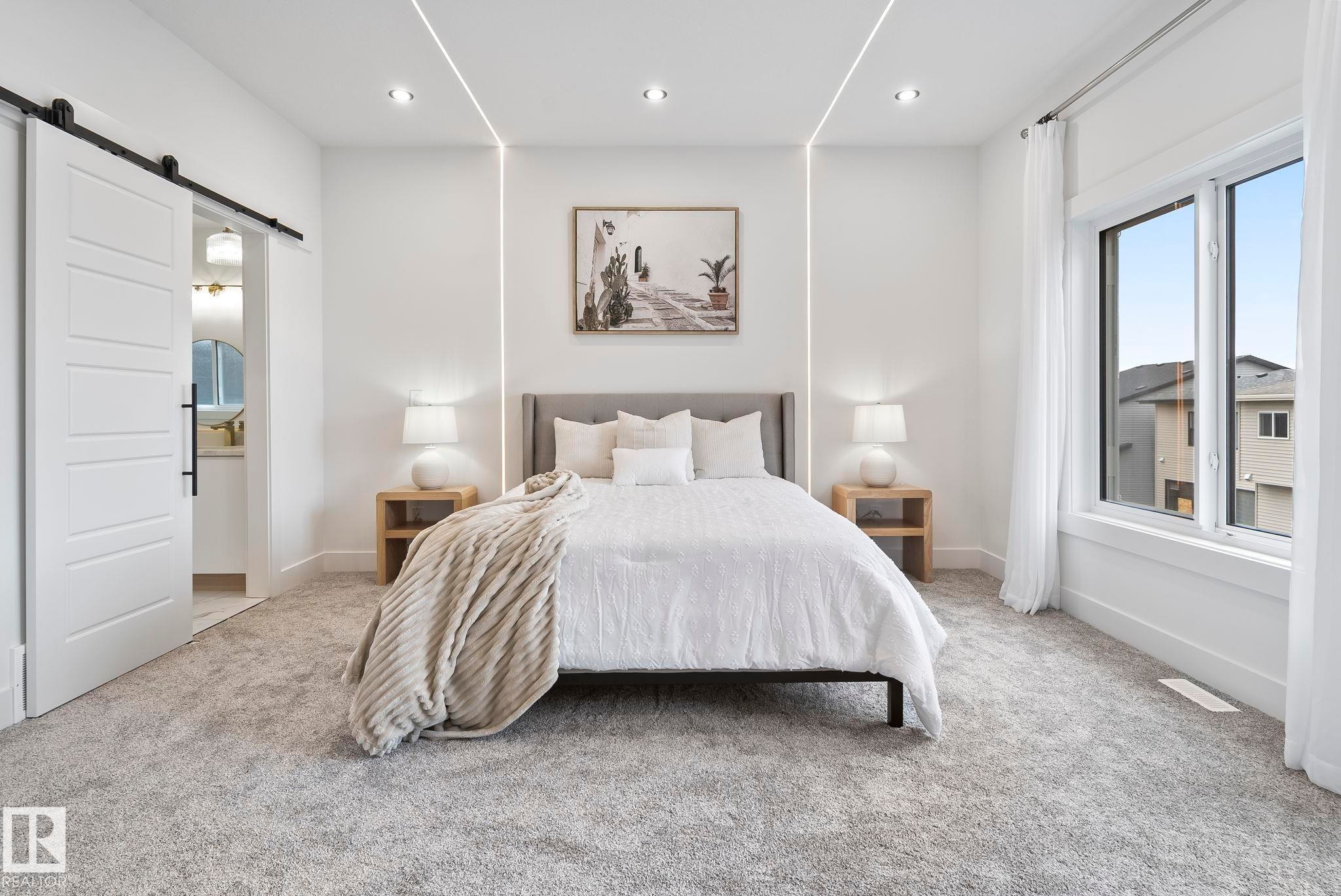 Spacious room featuring light gray carpeting, recessed ceiling lighting, and integrated linear wall lighting - 13152 187 Avenue, Edmonton, AB