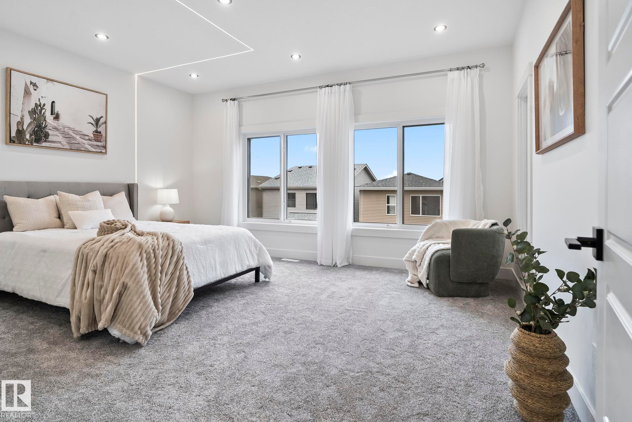 Bright bedroom featuring plush grey carpet and large windows with white trim - 13152 187 Avenue, Edmonton, AB