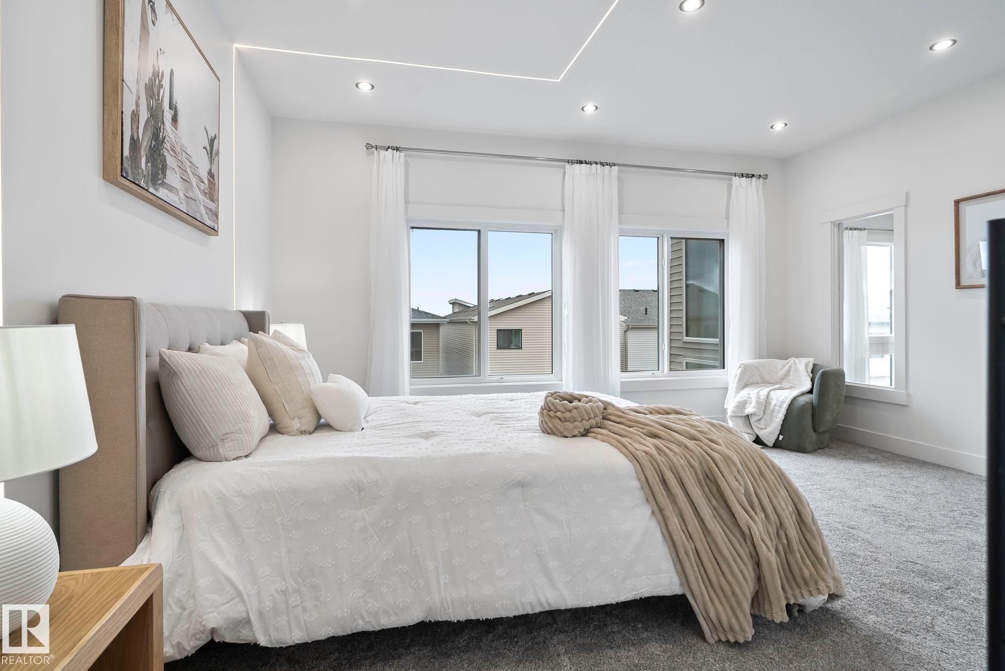 Spacious room featuring multiple large windows, recessed ceiling lighting, and perimeter cove lighting - 13152 187 Avenue, Edmonton, AB