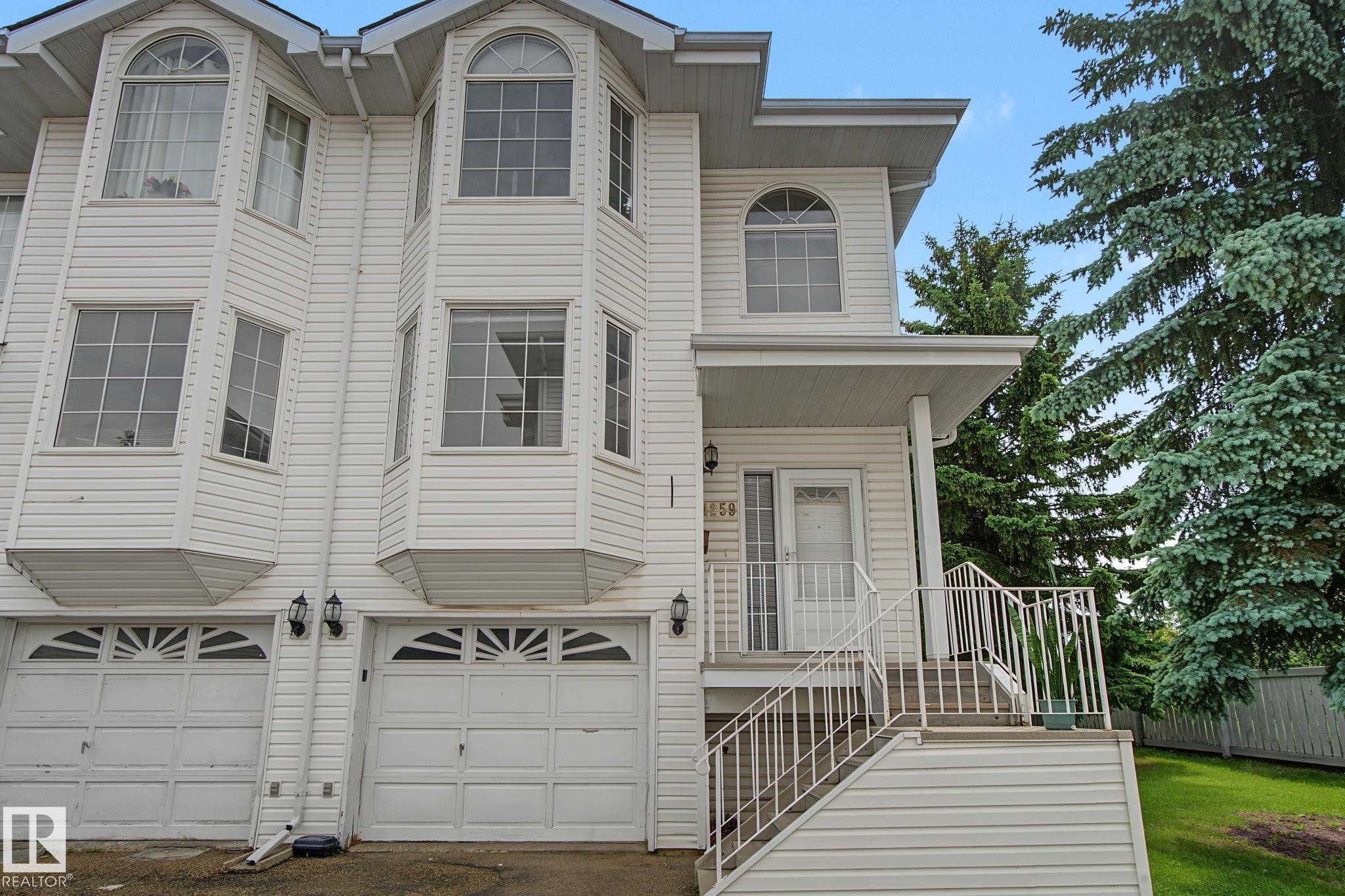 White siding exterior with multiple bay windows and arched window details - 4259 29 Avenue, Edmonton, AB