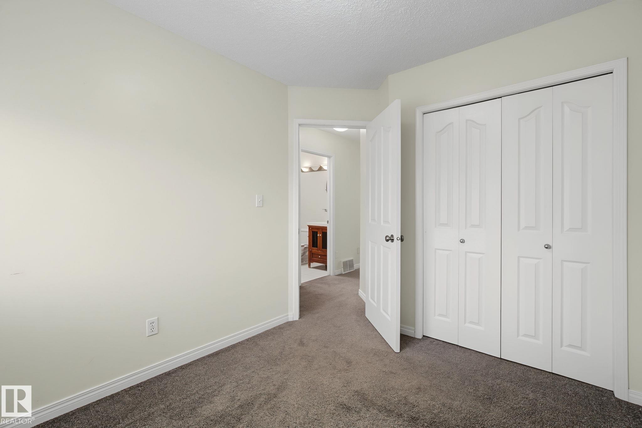 Room featuring neutral wall paint, white trim, and gray carpet flooring - 4259 29 Avenue, Edmonton, AB
