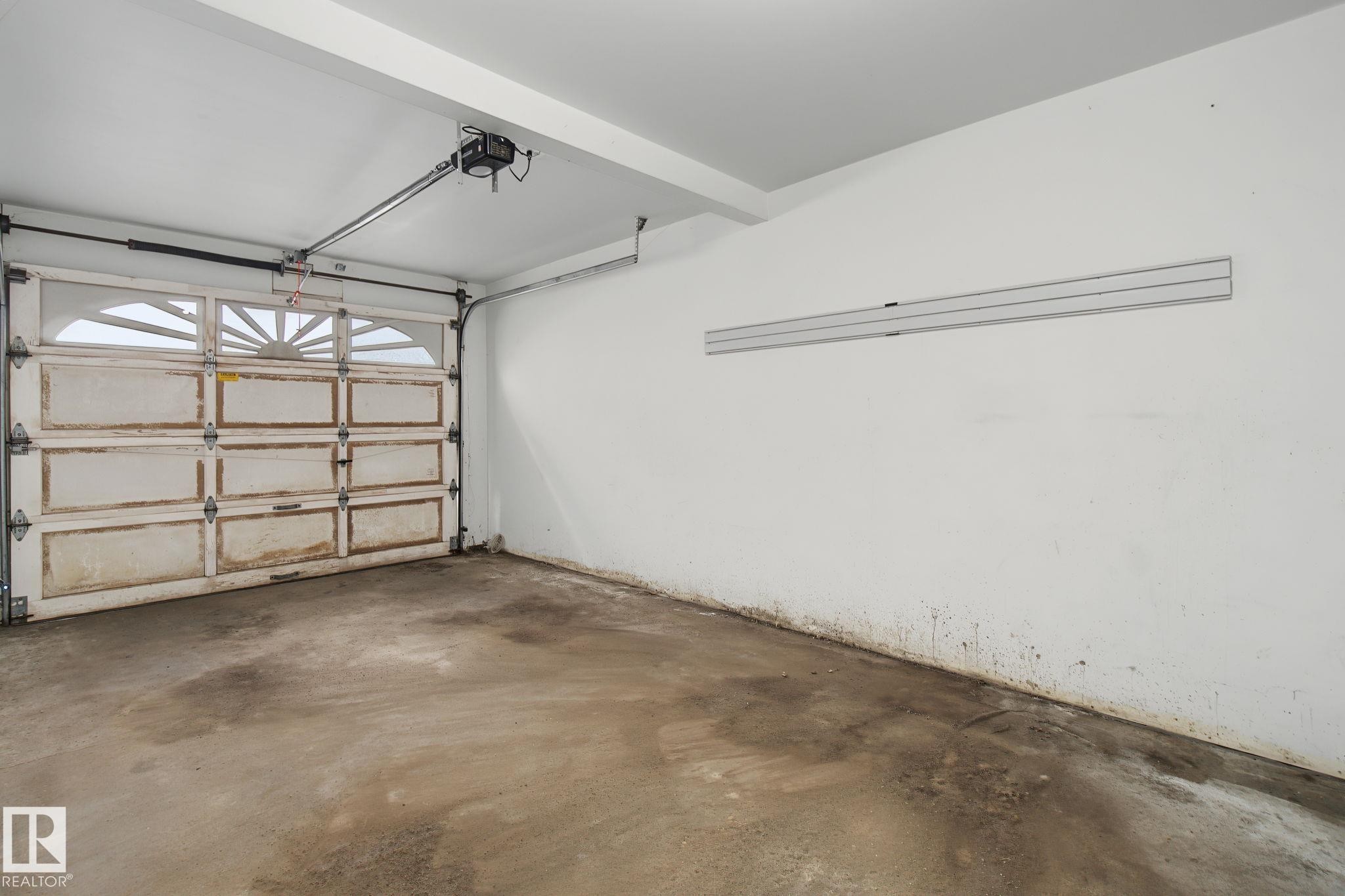 Single-car garage featuring a concrete floor and white painted walls - 4259 29 Avenue, Edmonton, AB