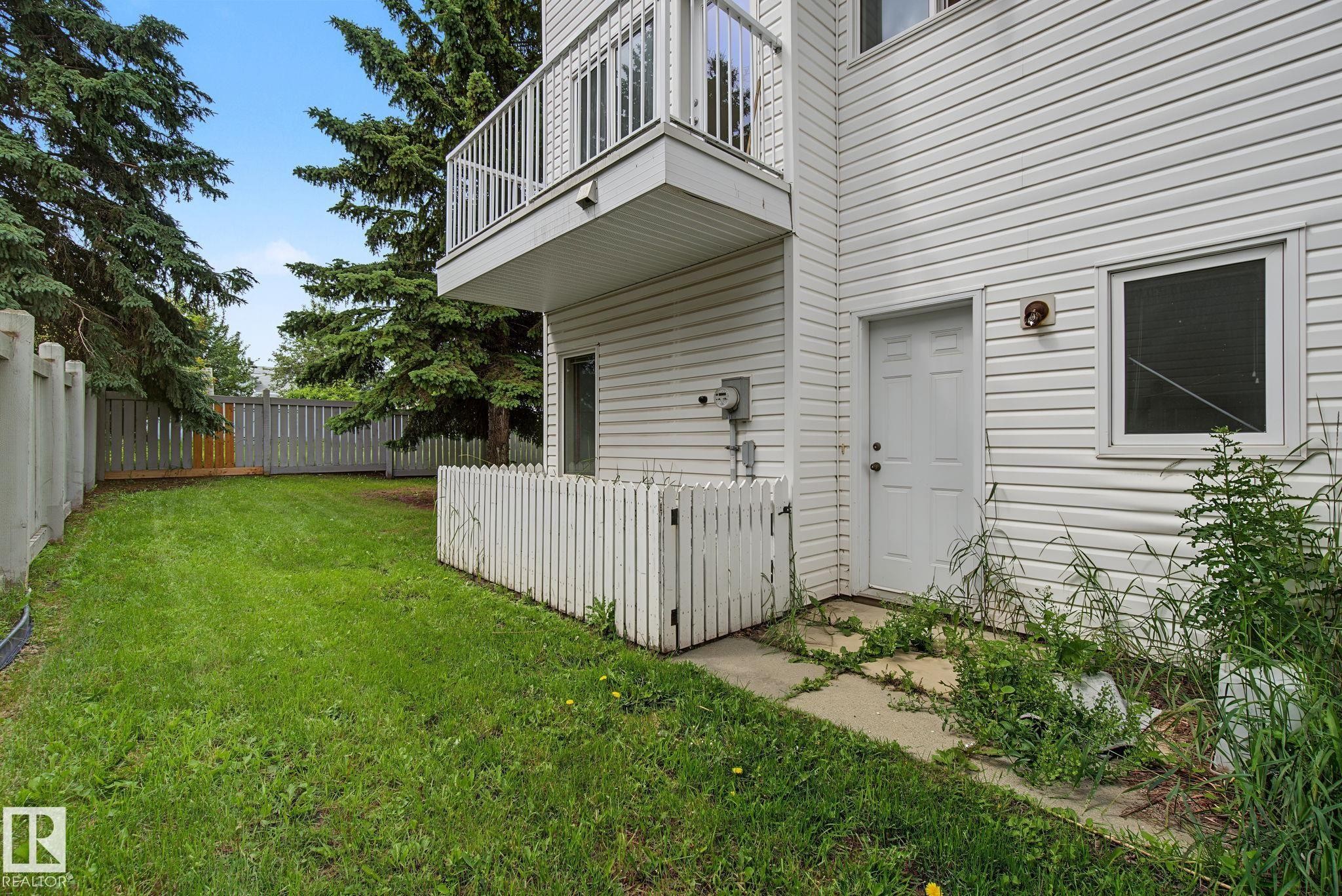 Spacious grass area bordered by a privacy fence and mature trees - 4259 29 Avenue, Edmonton, AB