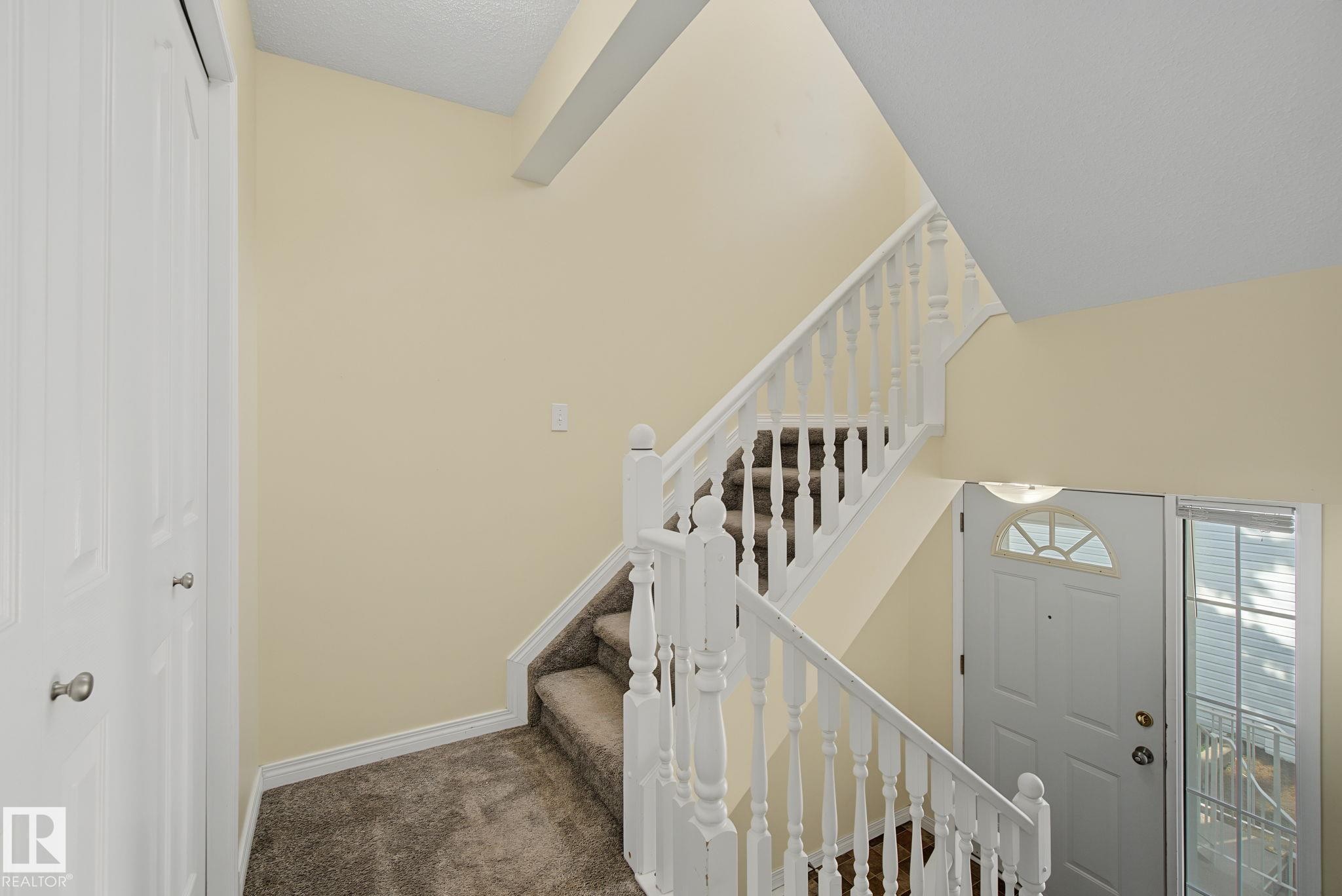 Staircase with white balusters and carpeted treads - 4259 29 Avenue, Edmonton, AB