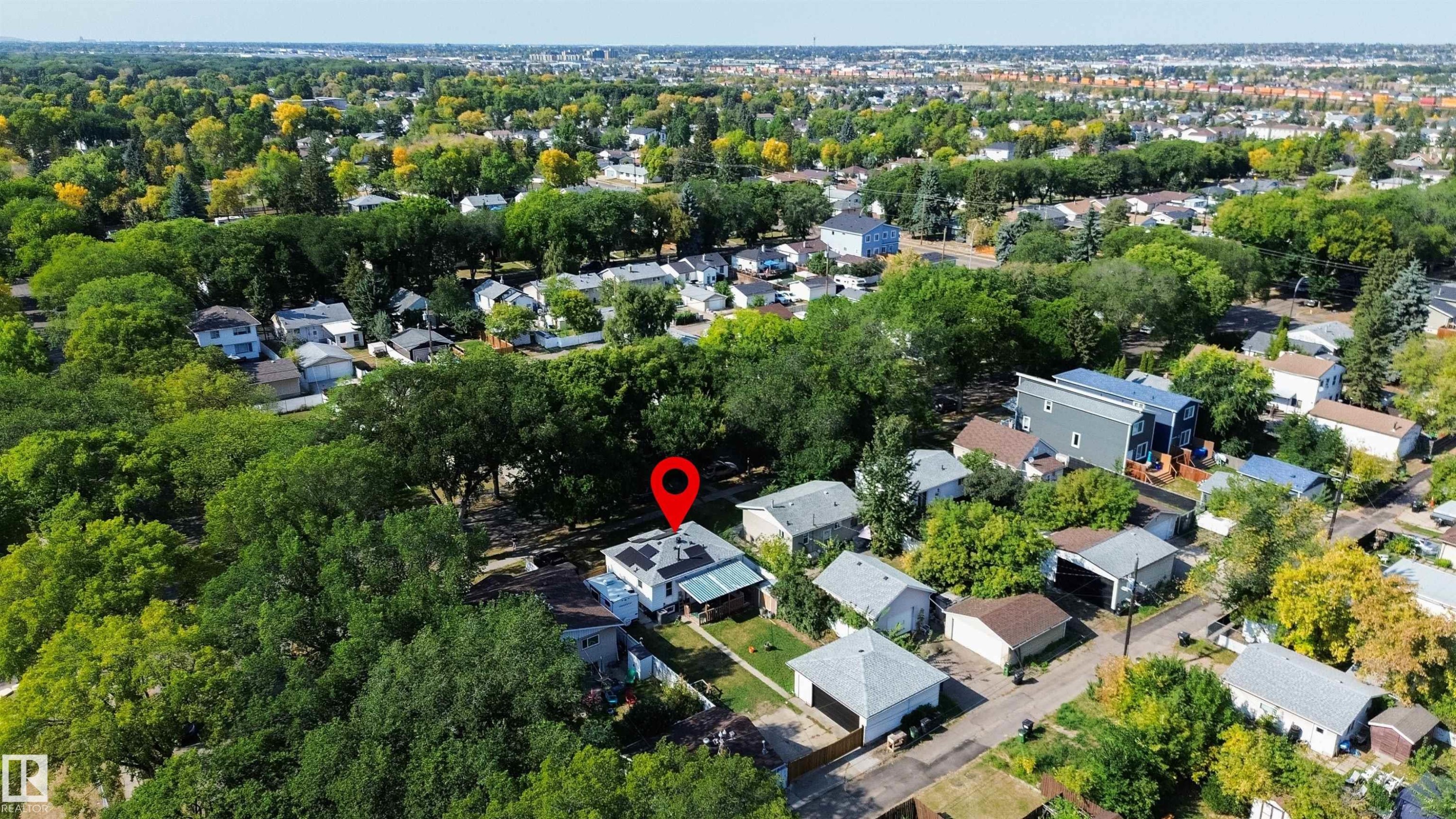 Residential property featuring solar panels on the roof and a surrounding neighborhood with mature trees - 12005 40 St Nw, Edmonton, AB - Outdoor With View