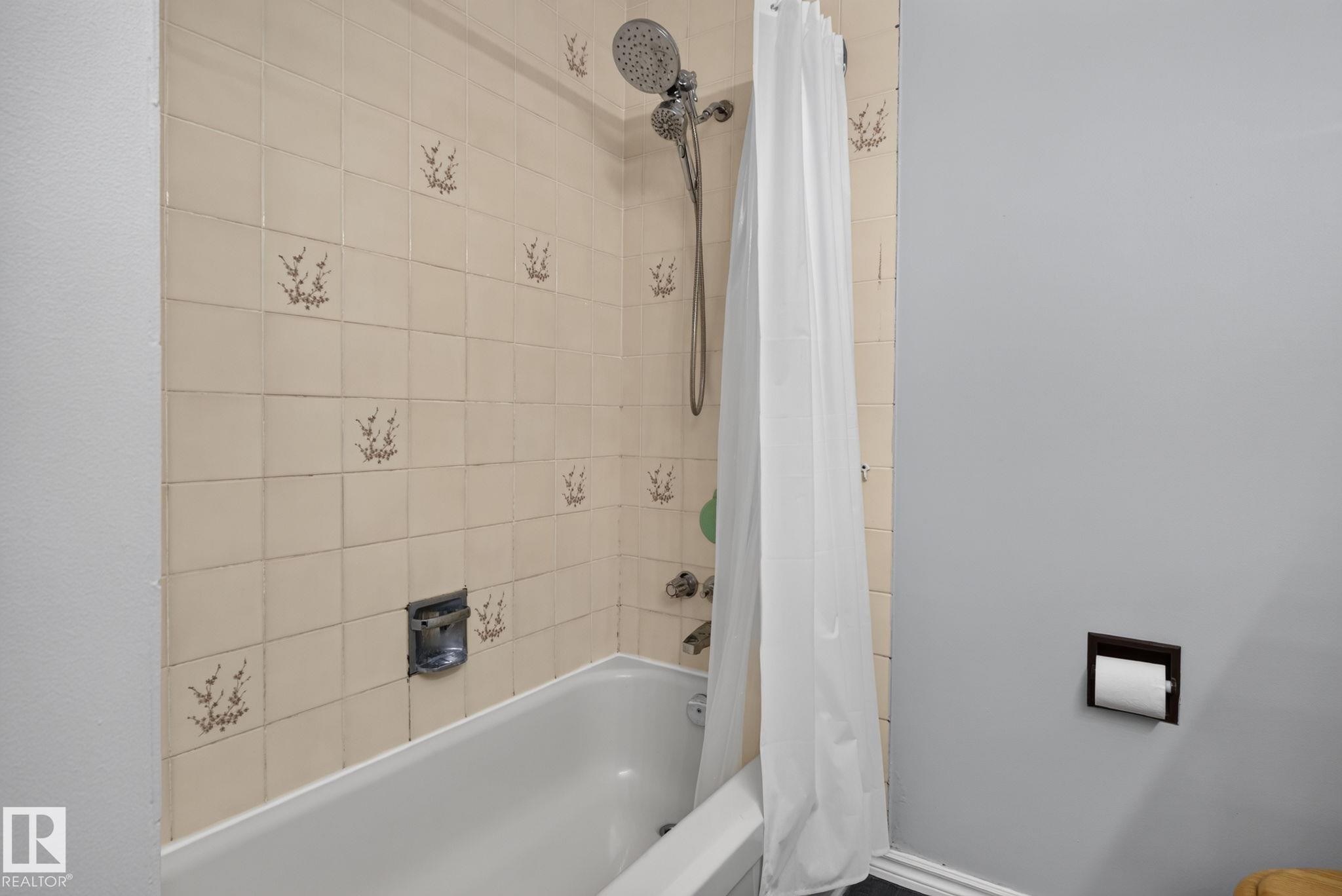 Bathroom tub and shower combination featuring decorative wall tiling - 3218 41 Street, Leduc, AB