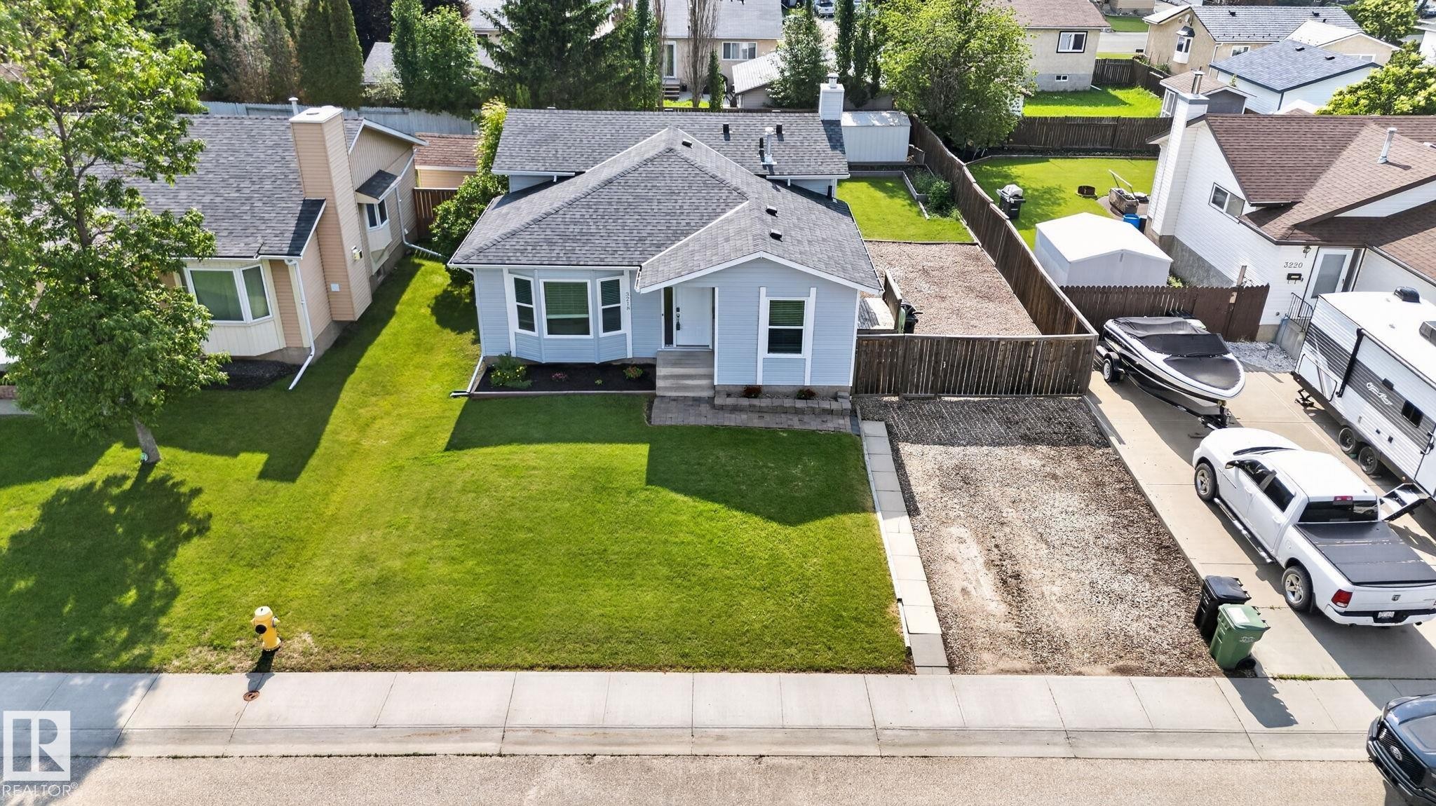Light blue exterior with a dark shingle roof and white trim - 3218 41 Street, Leduc, AB