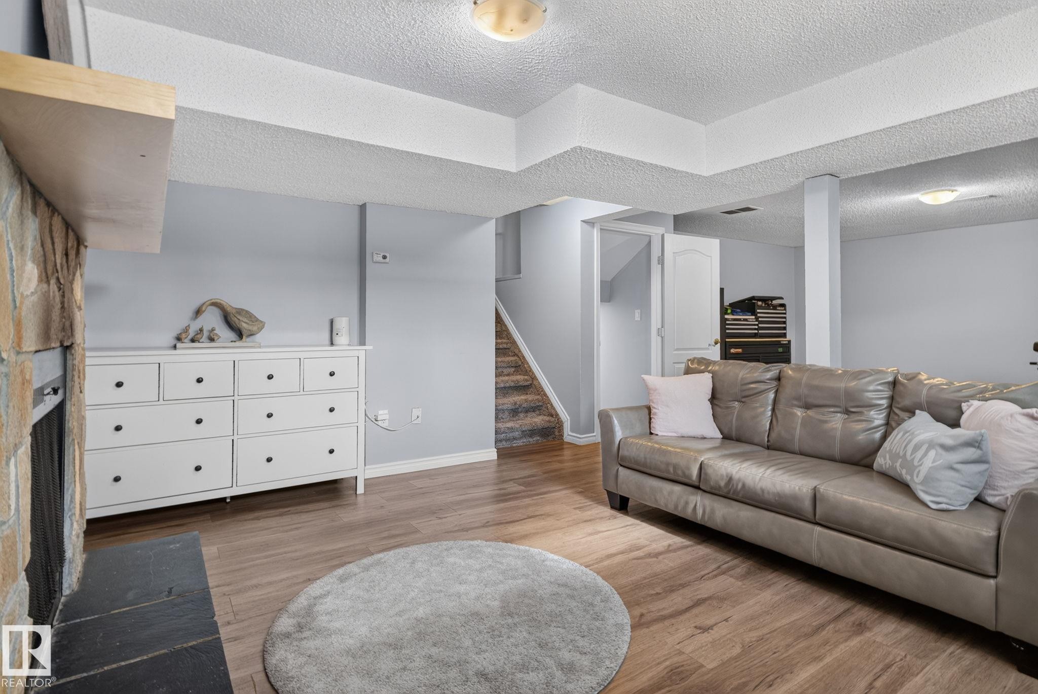 Lower level living area featuring wood-finish flooring, light gray wall paint, and recessed ceiling lighting - 3218 41 Street, Leduc, AB