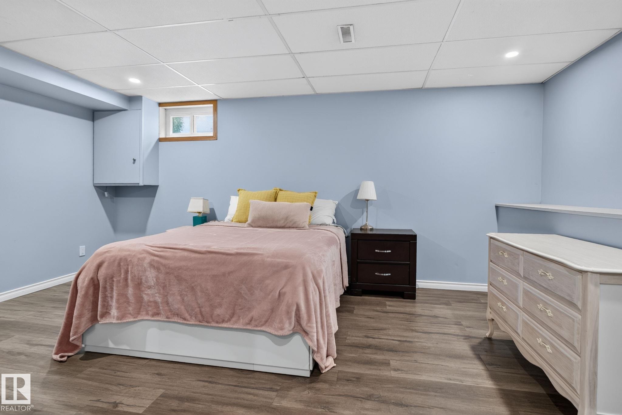 Spacious room featuring wood-finish flooring, light blue walls, and a white drop ceiling with recessed lighting - 3218 41 Street, Leduc, AB