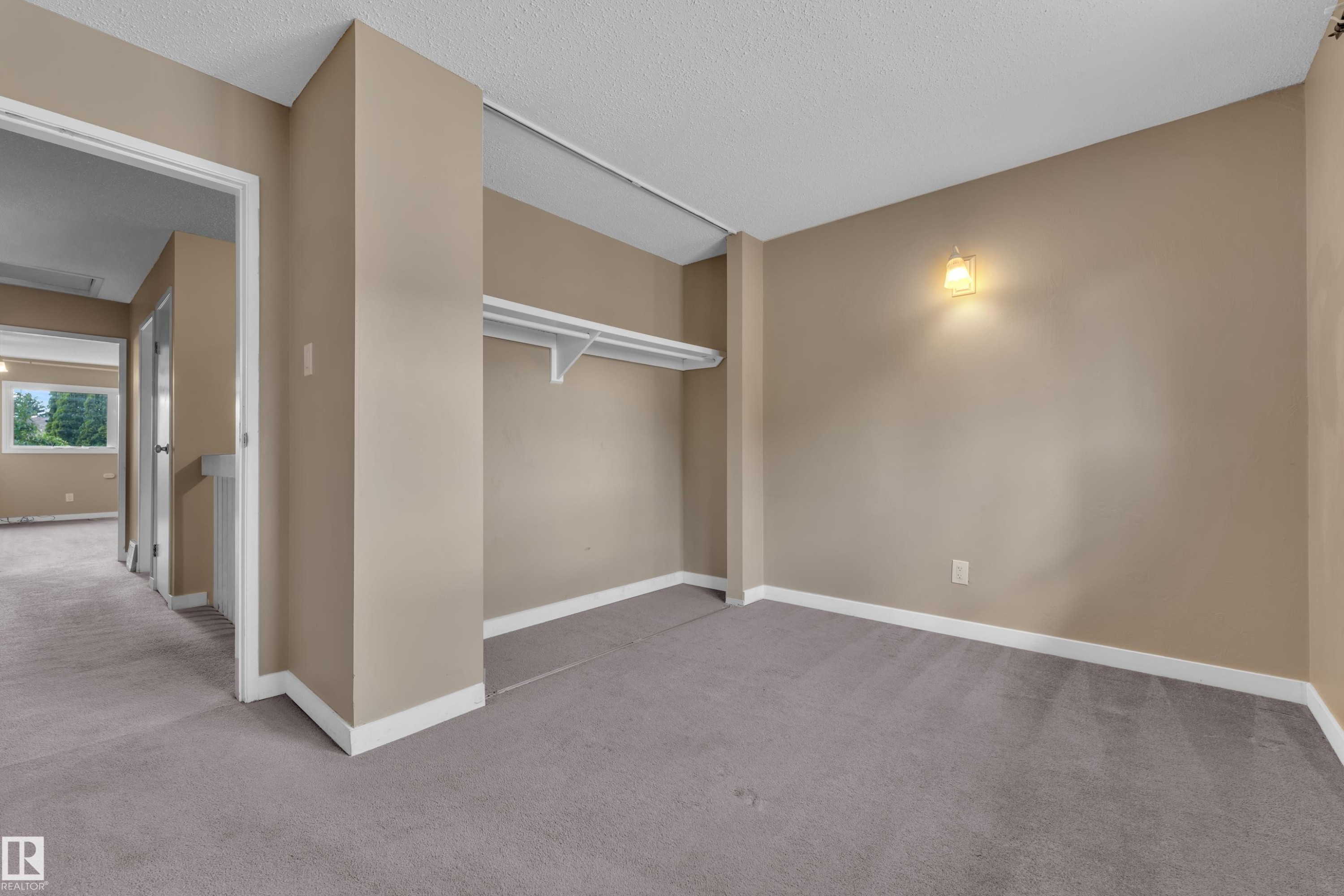 Interior room featuring neutral wall paint, gray carpeting, white baseboards, and a built-in closet shelf - 6632 36A Avenue, Edmonton, AB