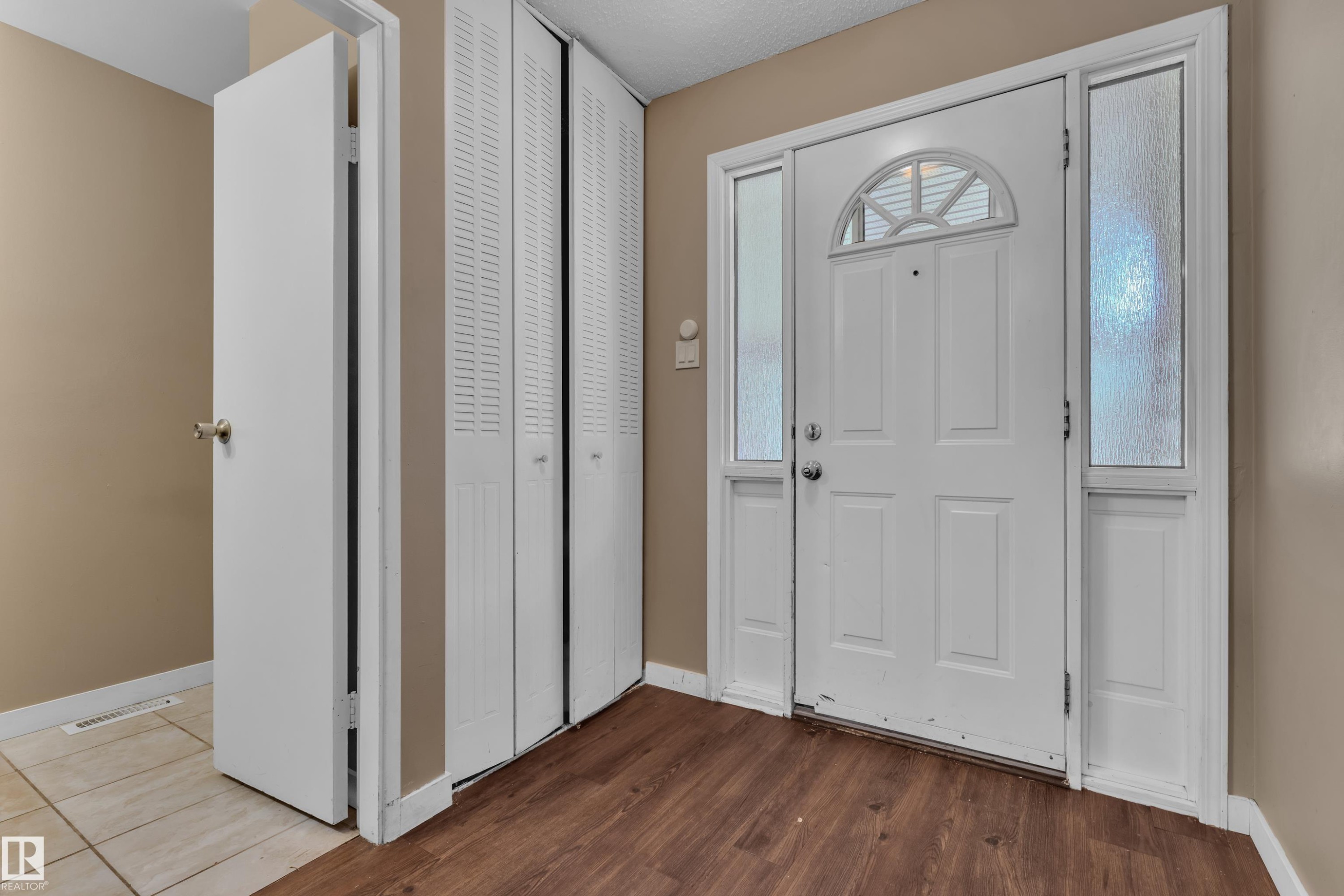 Entryway featuring a paneled door with an arched transom window and frosted sidelights - 6632 36A Avenue, Edmonton, AB