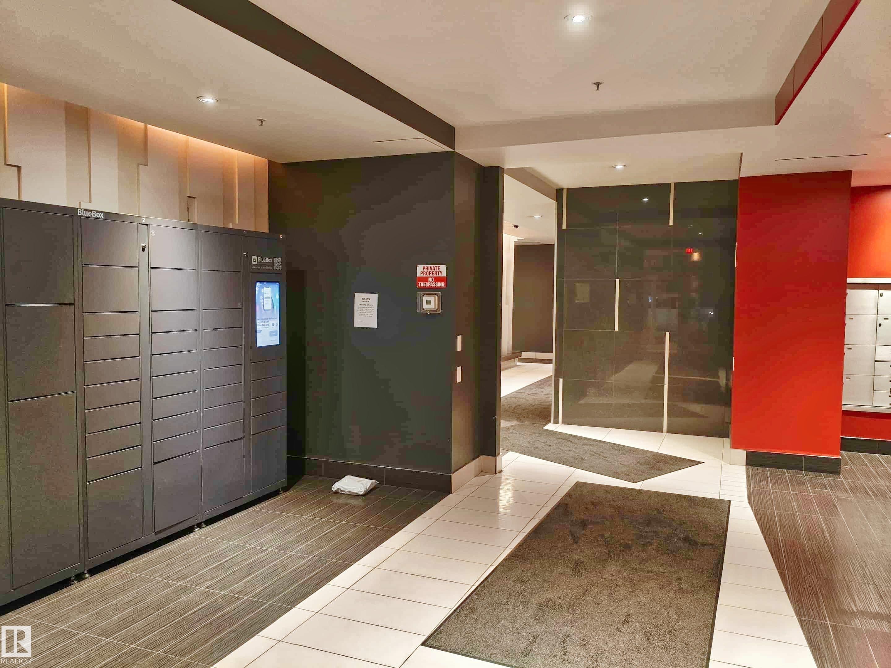 Modern entryway featuring parcel lockers and mailboxes - #2505 10410 102 Av Nw, Edmonton, AB - Indoor