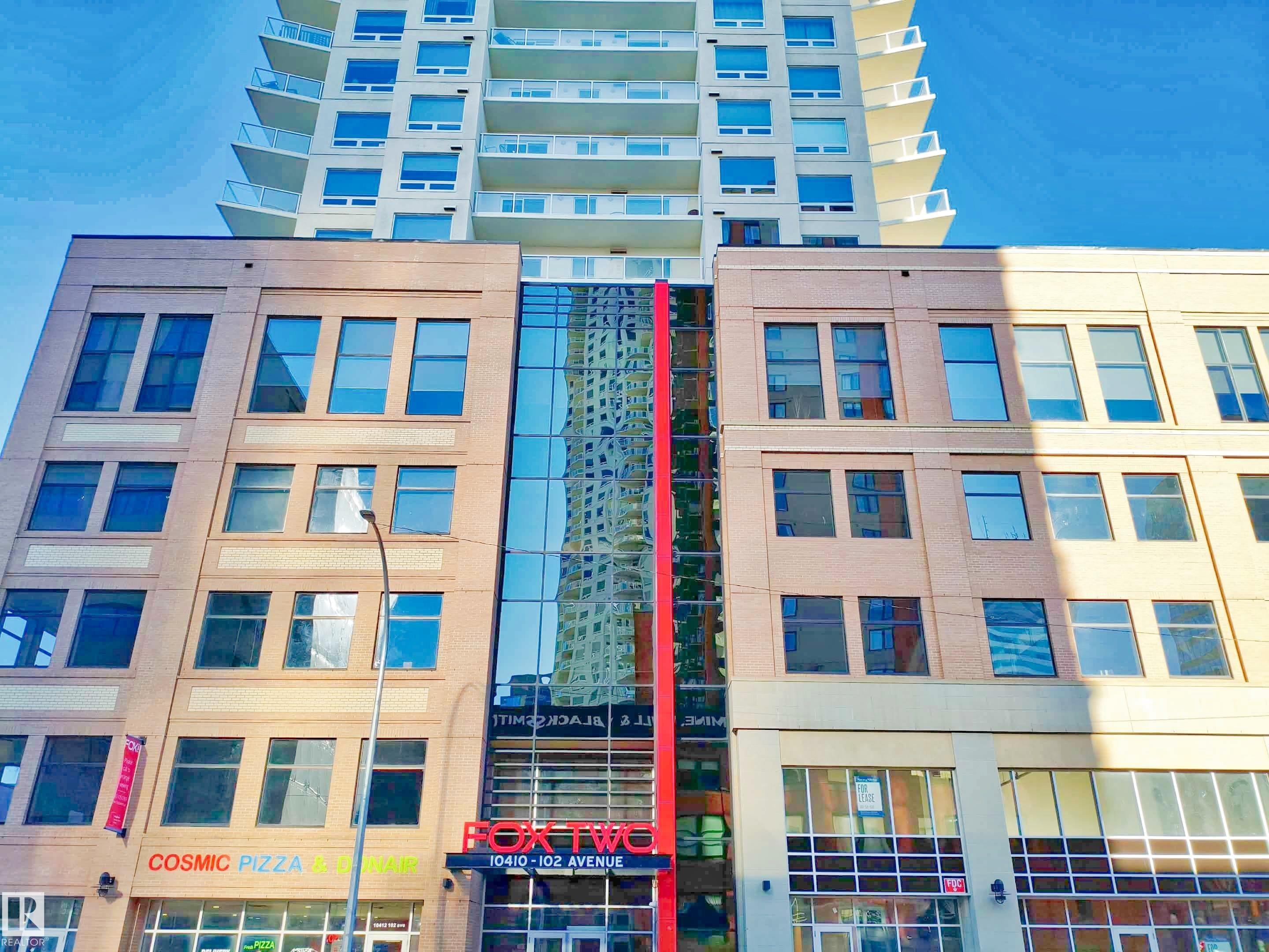 Modern mixed-use building featuring a multi-story glass facade and a prominent "BOX TWO" sign - #2505 10410 102 Av Nw, Edmonton, AB - Outdoor With Facade