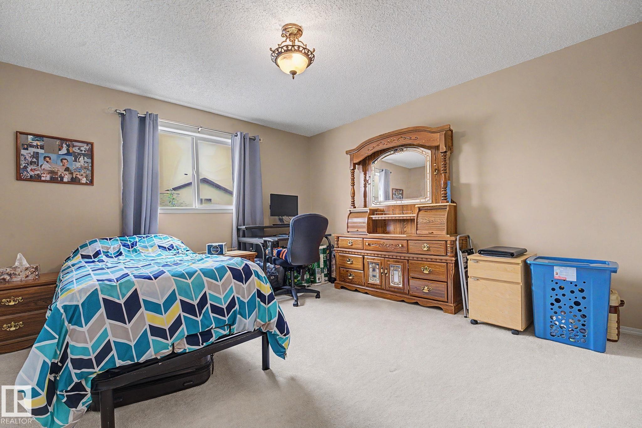 Carpeted room featuring a window with drapes, a ceiling-mounted light fixture, and neutral-toned walls - 19039 47 Avenue Nw, Edmonton, AB - Indoor Photo Showing Bedroom