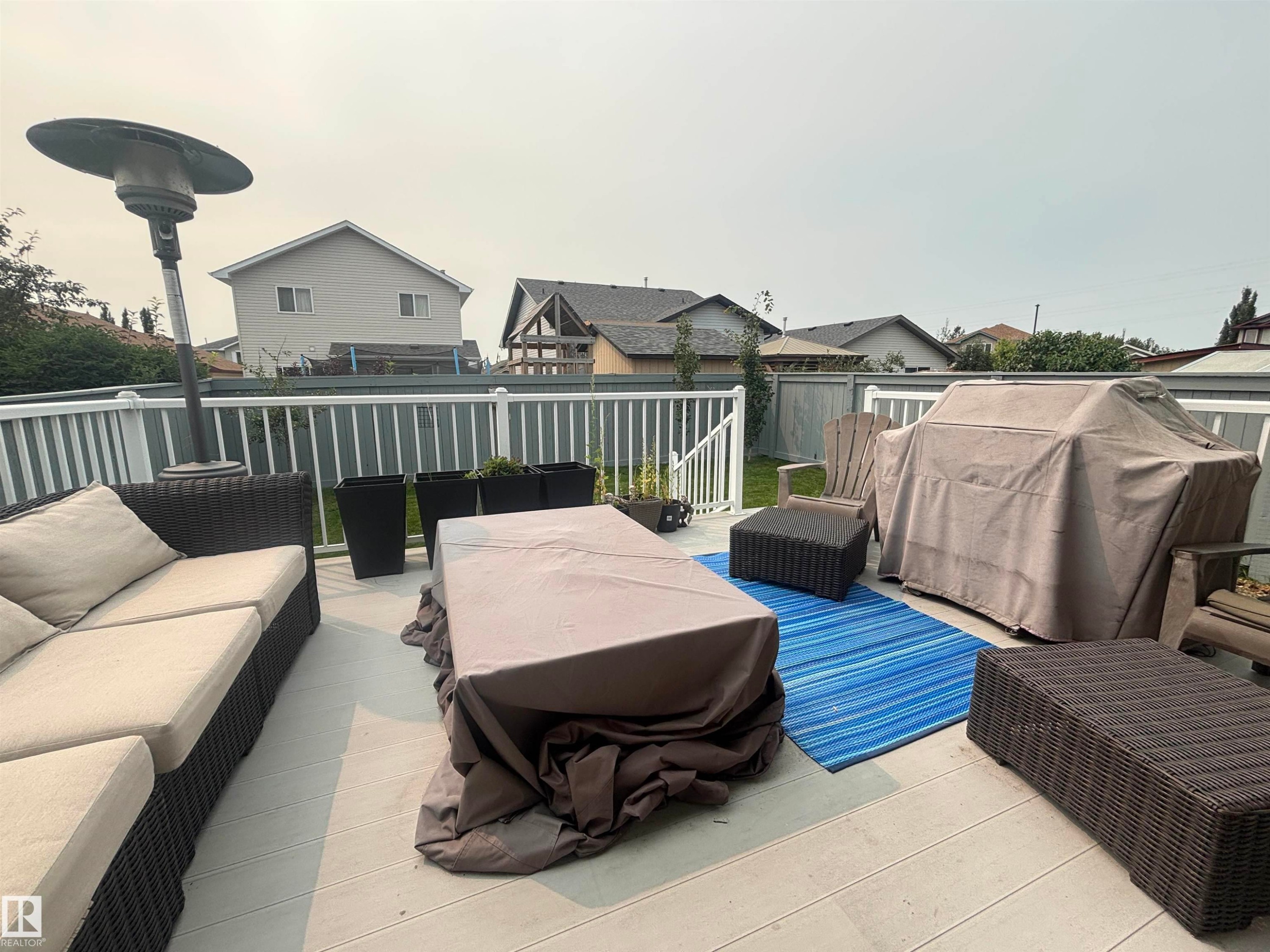 Spacious outdoor deck featuring light-toned composite decking, white railing, and a privacy fence - 19039 47 Avenue Nw, Edmonton, AB - Outdoor With Deck Patio Veranda With Exterior