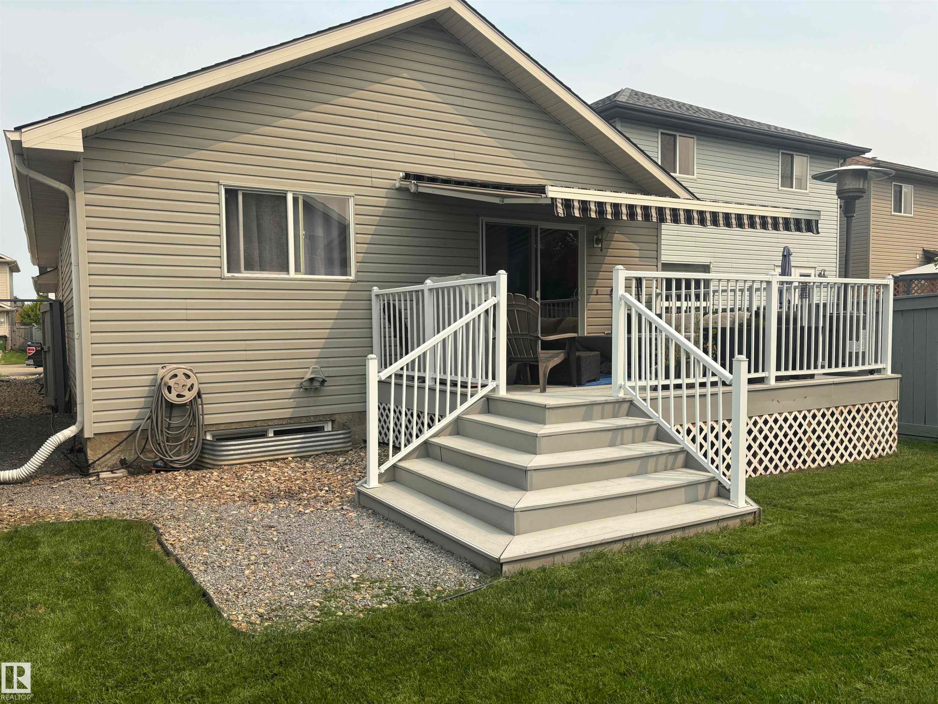 Composite deck with white railing, multi-tiered steps, and an extendable awning - 19039 47 Avenue Nw, Edmonton, AB - Outdoor With Deck Patio Veranda With Exterior