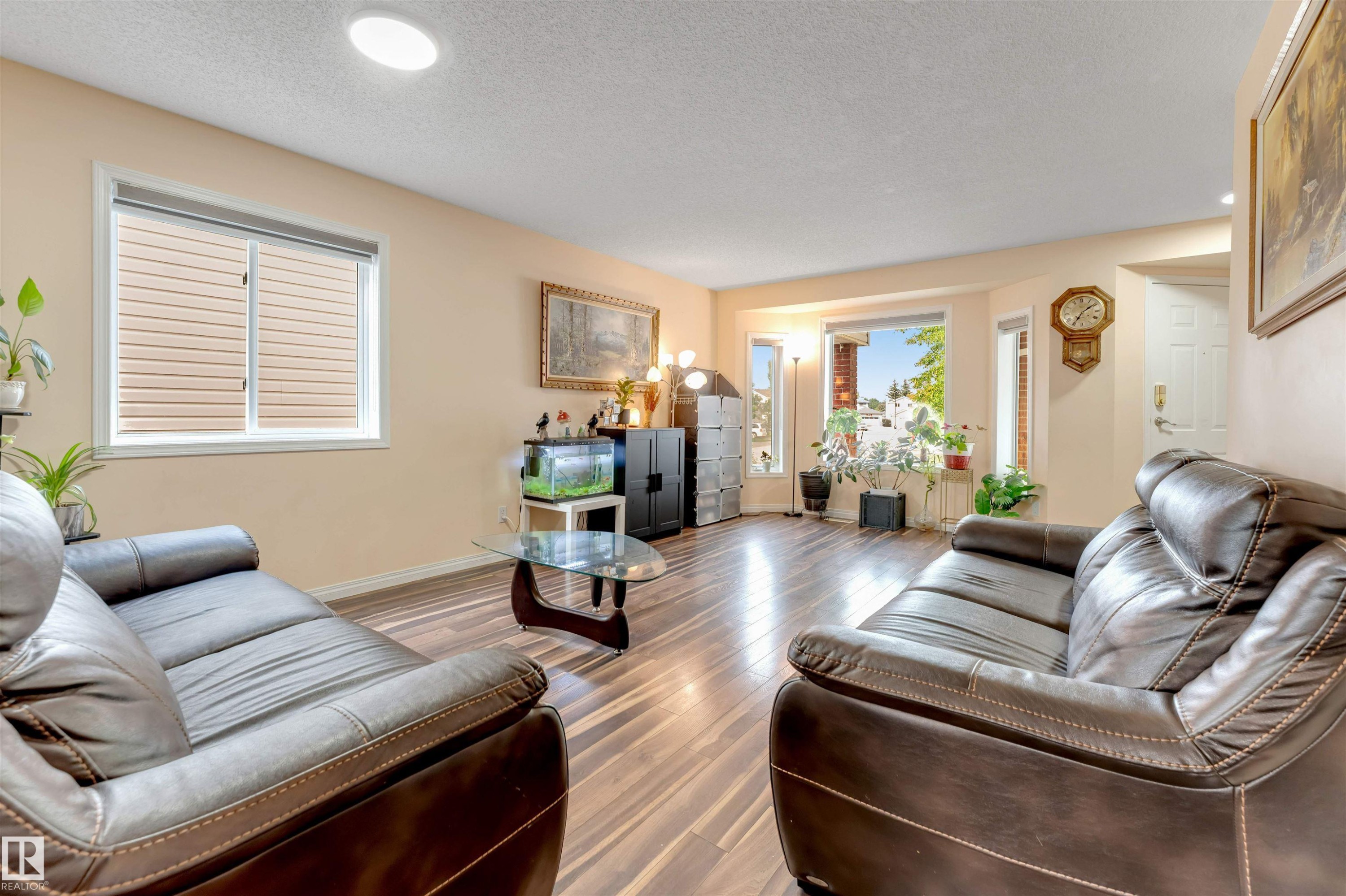 Spacious living area featuring wood-finish flooring, recessed lighting, a bay window, and light-colored walls - 312 Beringer Crescent Nw, Edmonton, AB - Indoor Photo Showing Living Room