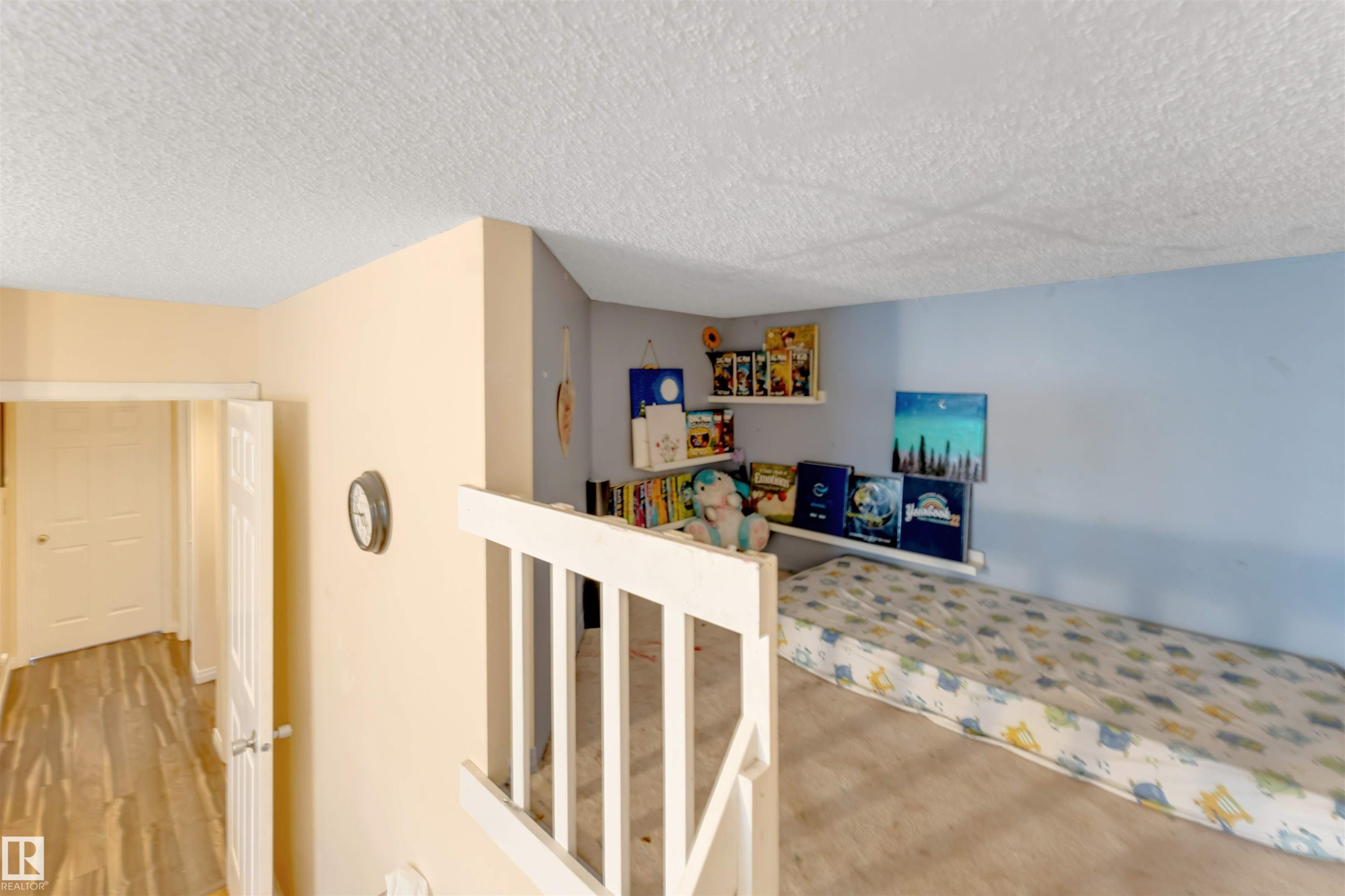 Loft space featuring a light blue accent wall, recessed shelving, and a textured ceiling - 312 Beringer Crescent Nw, Edmonton, AB - Indoor Photo Showing Other Room