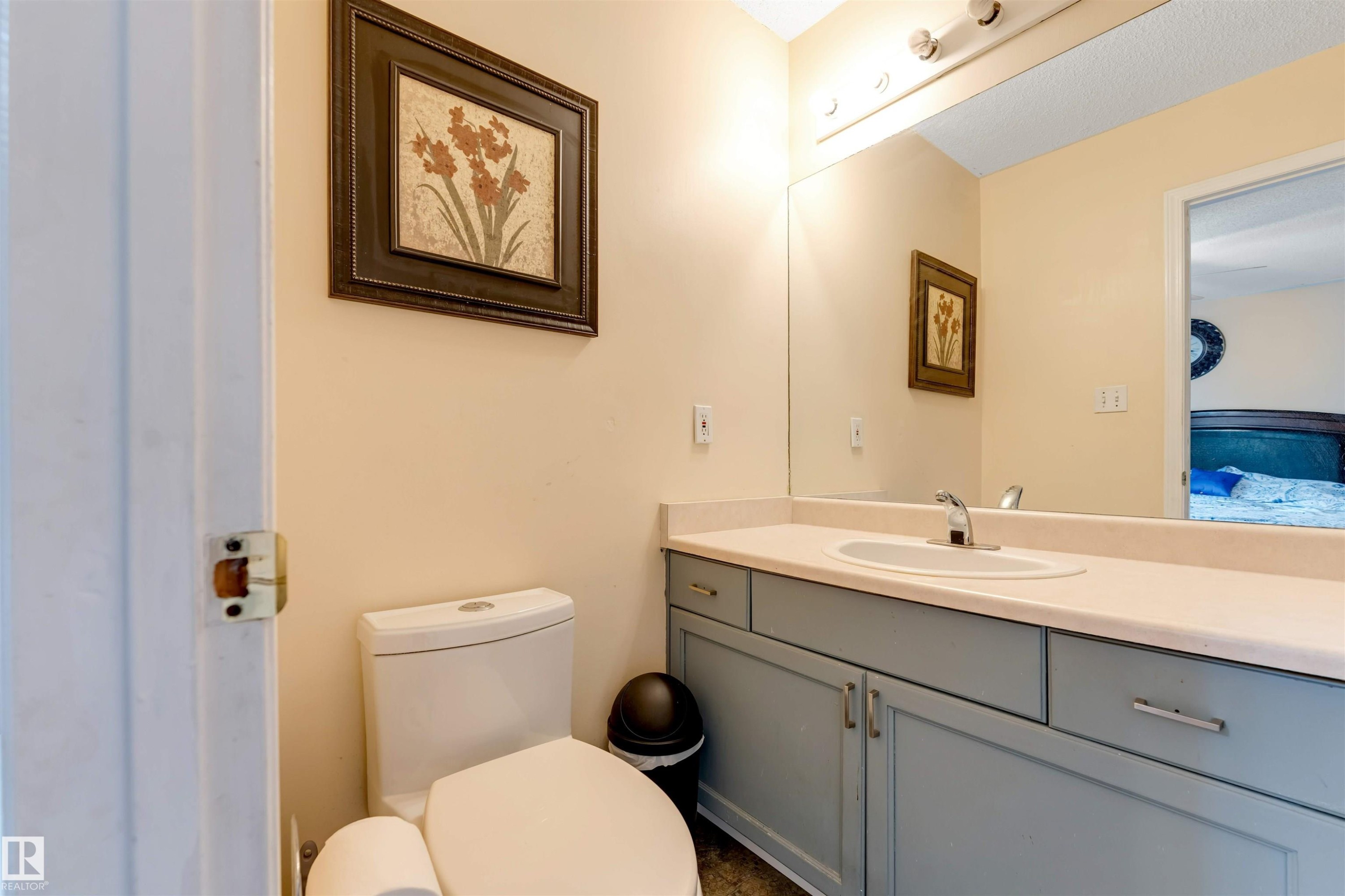 Bathroom featuring a contemporary vanity with a light countertop, integrated sink, and brushed chrome faucet - 312 Beringer Crescent Nw, Edmonton, AB - Indoor Photo Showing Bathroom