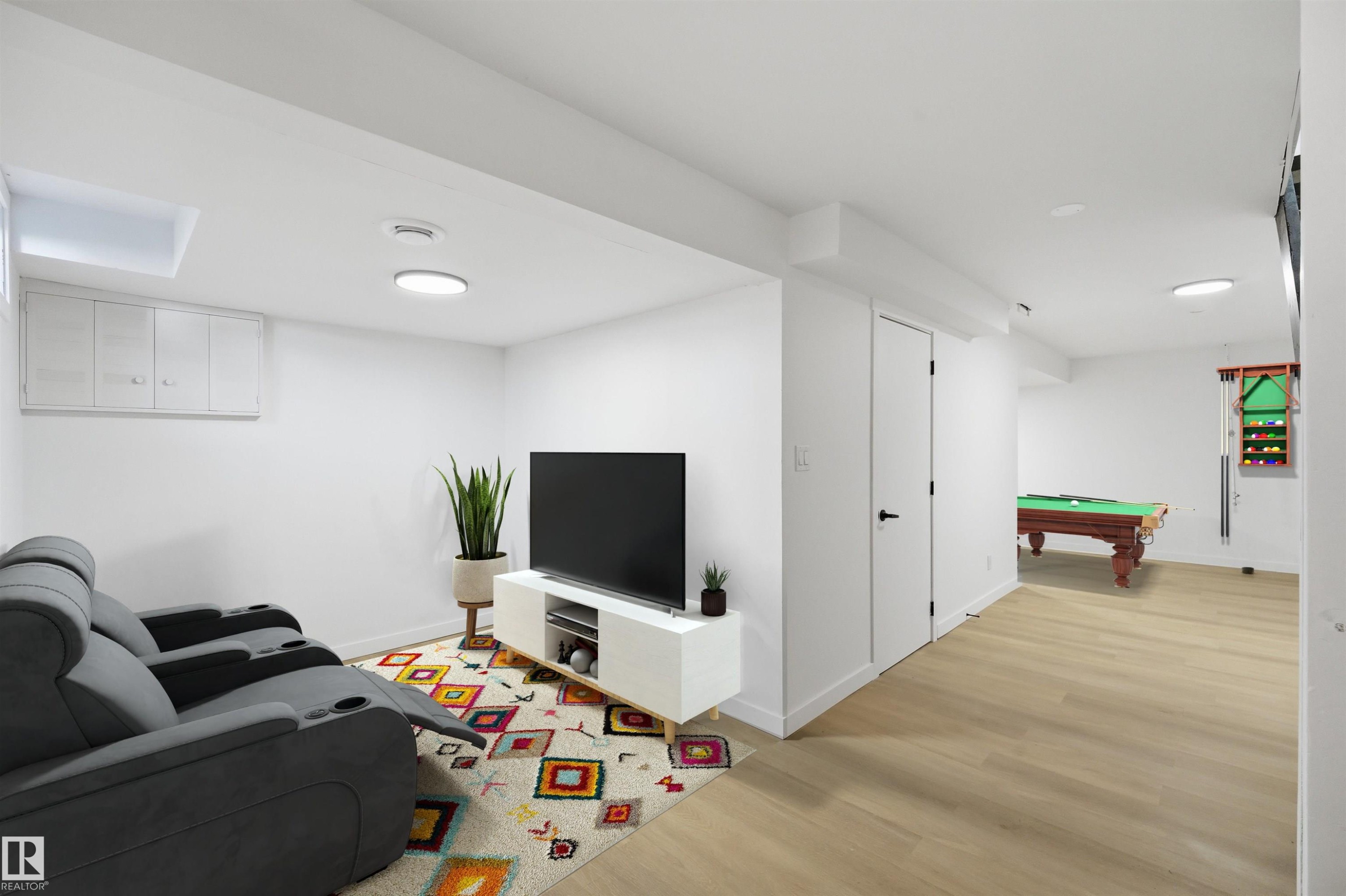 Lower level recreation area featuring light wood-finish flooring and recessed lighting - 21 Lakewood Village Nw, Edmonton, AB - Indoor