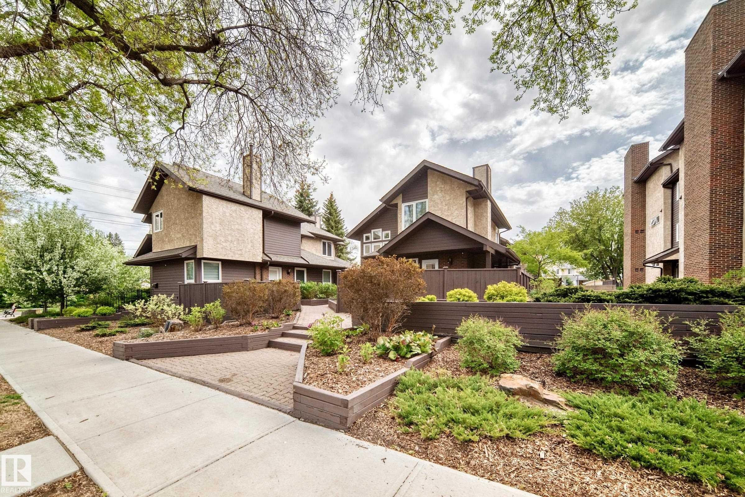 Contemporary exterior featuring a combination of stucco and dark siding, pitched rooflines, and prominent chimneys - 7930 111 Street, Edmonton, AB - Outdoor