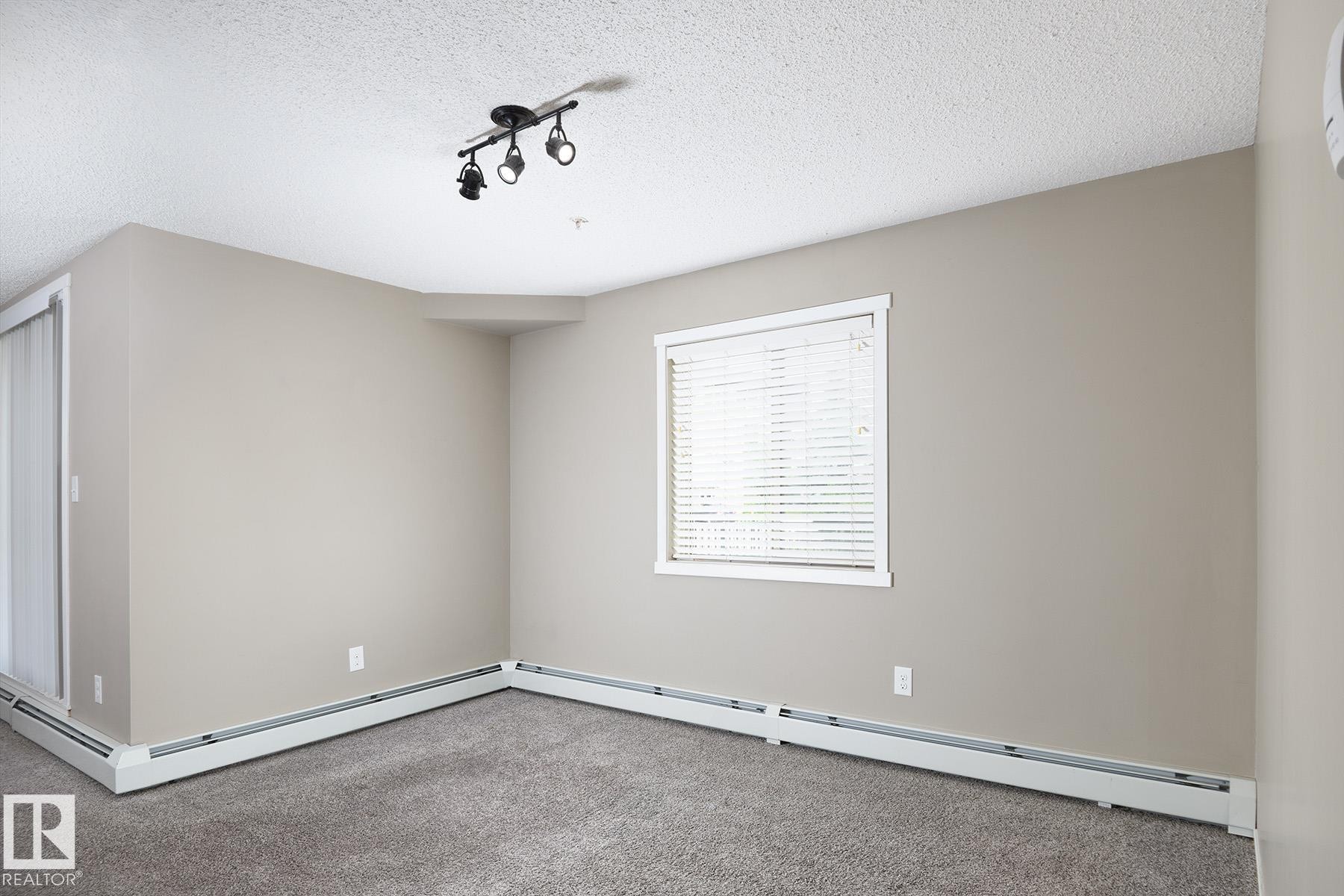 Neutral-toned walls complement plush grey carpeting - 102 25 Element Dr, St. Albert, AB