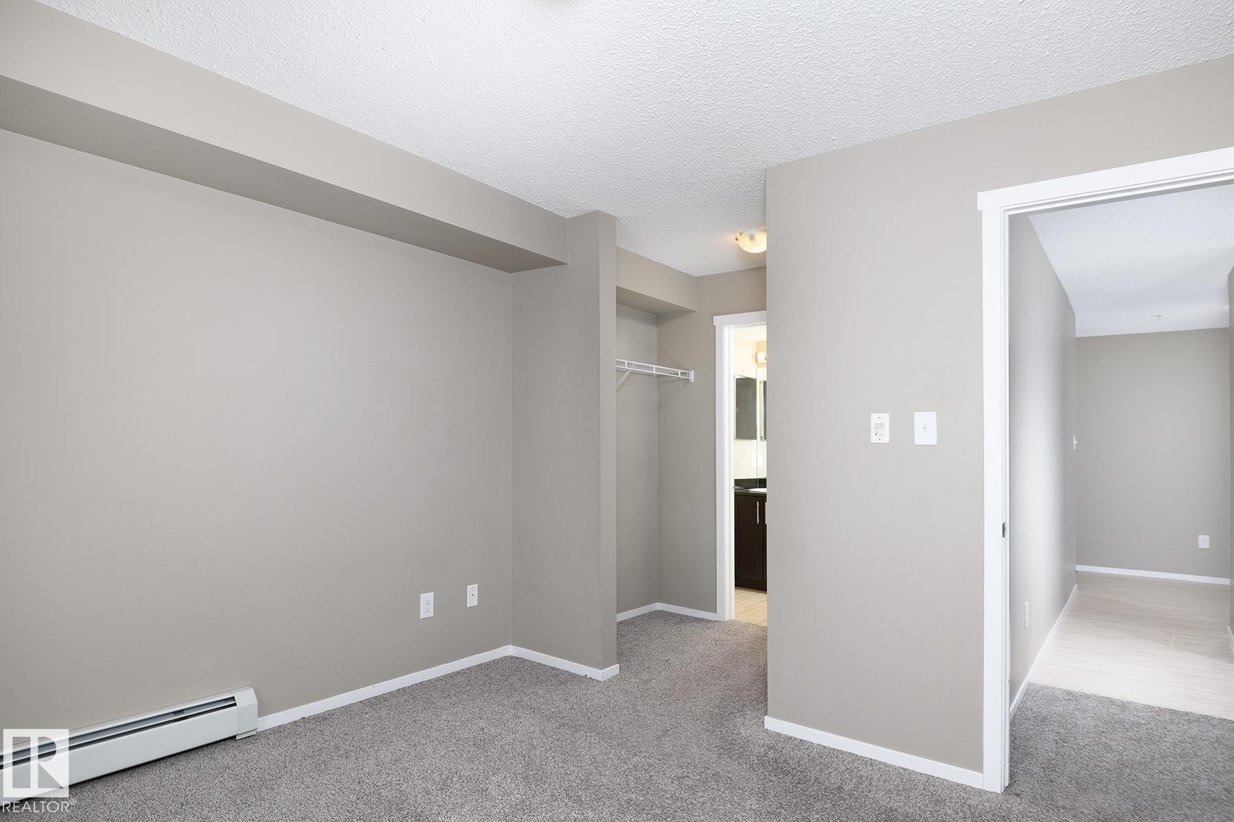 Neutral-toned walls complement plush grey carpeting throughout this inviting interior space - 102 25 Element Dr, St. Albert, AB