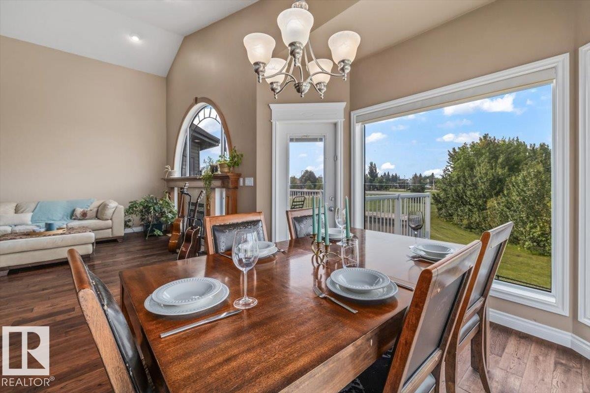Vaulted ceilings enhance this dining area, featuring wood-finish flooring and a large picture window - 215 Westerra Point(E), Stony Plain, AB