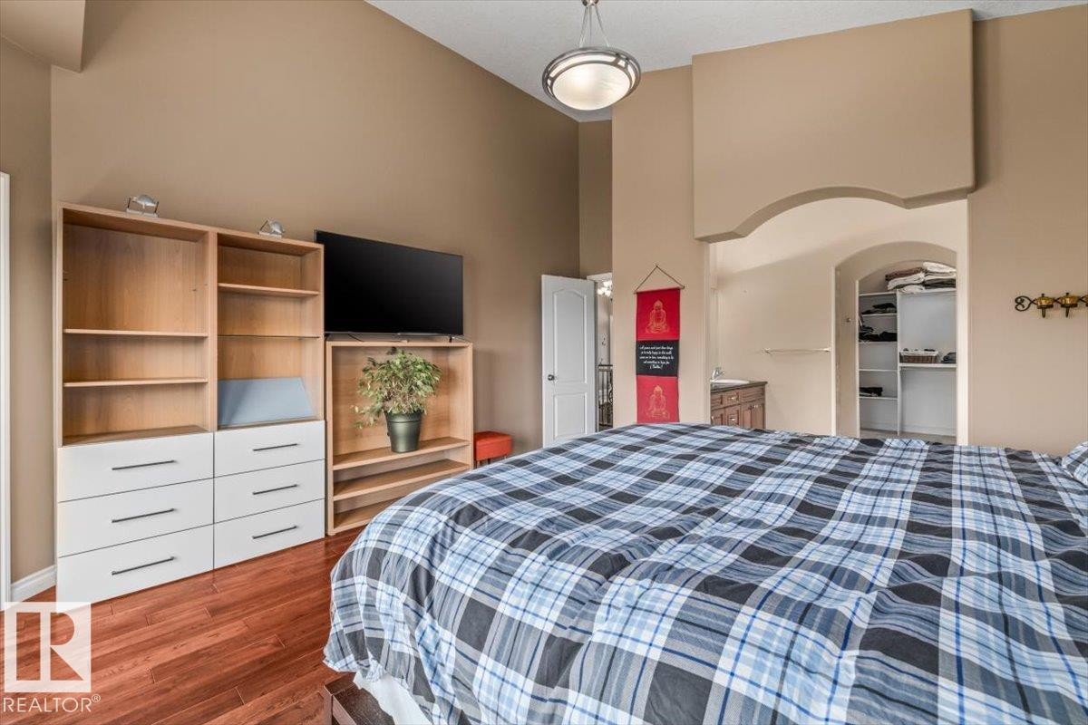 Bedroom featuring a vaulted ceiling and wood-finish flooring - 215 Westerra Point(E), Stony Plain, AB