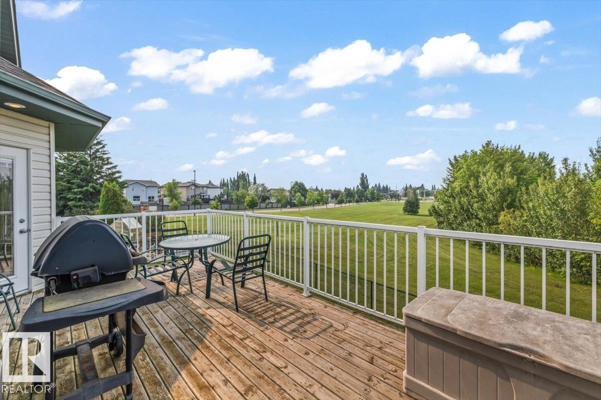 Expansive wood-finish deck with white railing, offering abundant outdoor space - 215 Westerra Point(E), Stony Plain, AB
