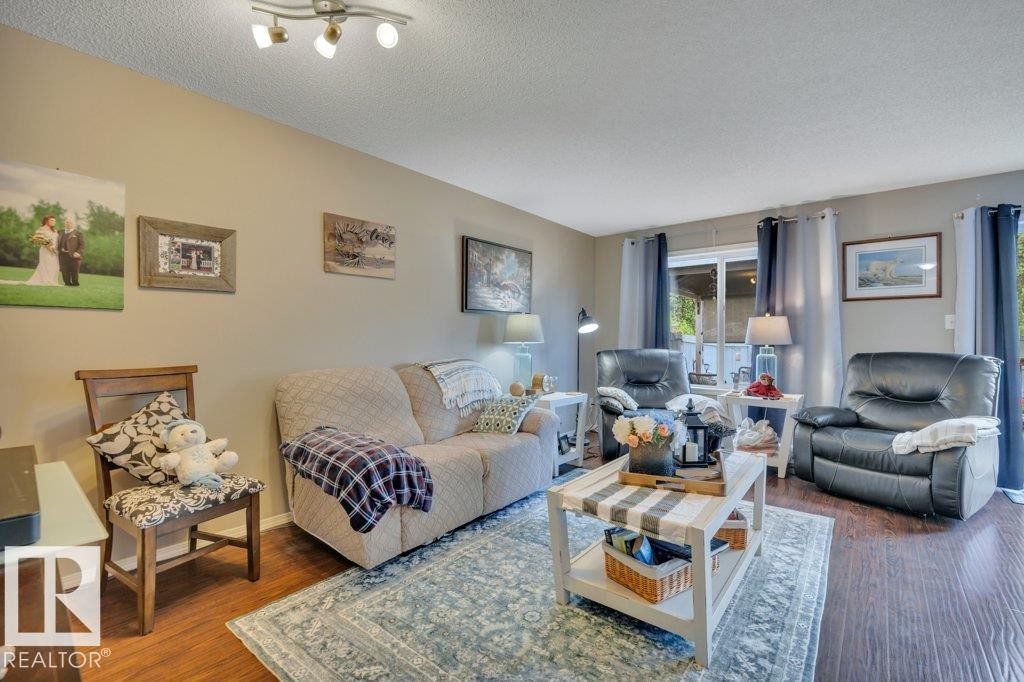 Living area featuring hardwood, light-colored walls, and a sliding glass door - 6042 214 Street, Edmonton, AB - Indoor Photo Showing Living Room