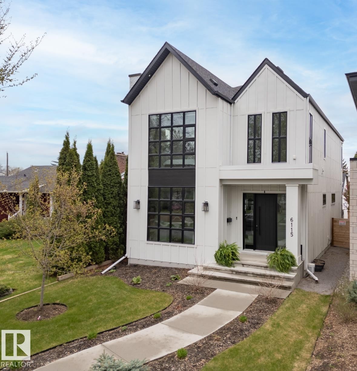 Contemporary two-story residence featuring a striking board and batten facade, prominent black-framed windows, and a covered entry - 6115 111 Avenue, Edmonton, AB - Outdoor With Facade