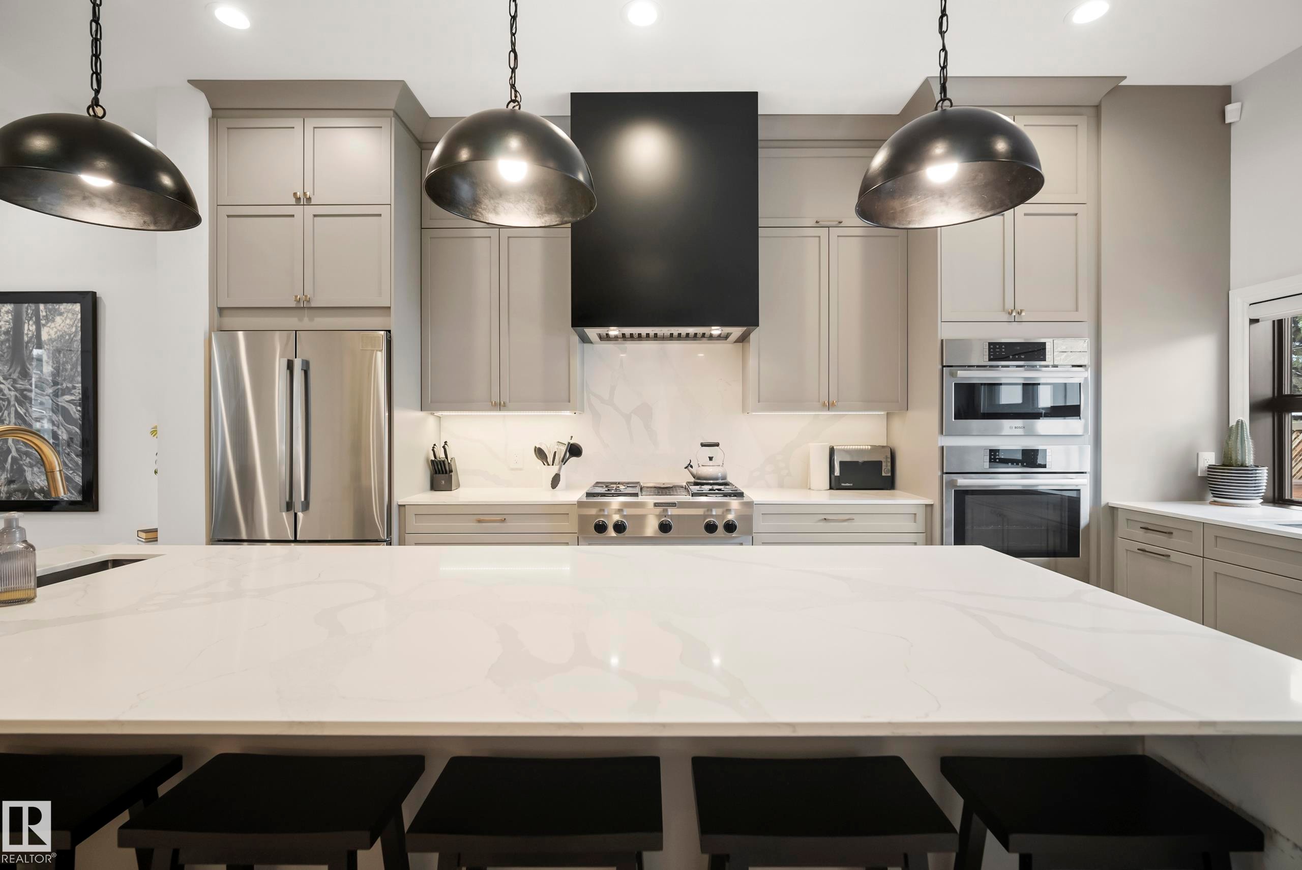 Expansive kitchen island with a light-toned countertop, complemented by pendant lighting - 6115 111 Avenue, Edmonton, AB - Indoor Photo Showing Kitchen With Double Sink With Upgraded Kitchen