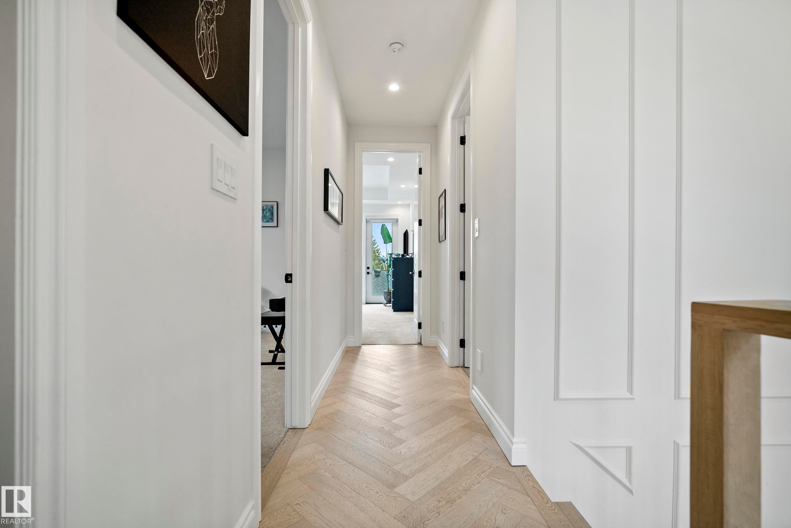 Hallway featuring light wood-finish herringbone flooring, recessed lighting, white baseboards, and board and batten wall detailing - 6115 111 Avenue, Edmonton, AB - Indoor Photo Showing Other Room