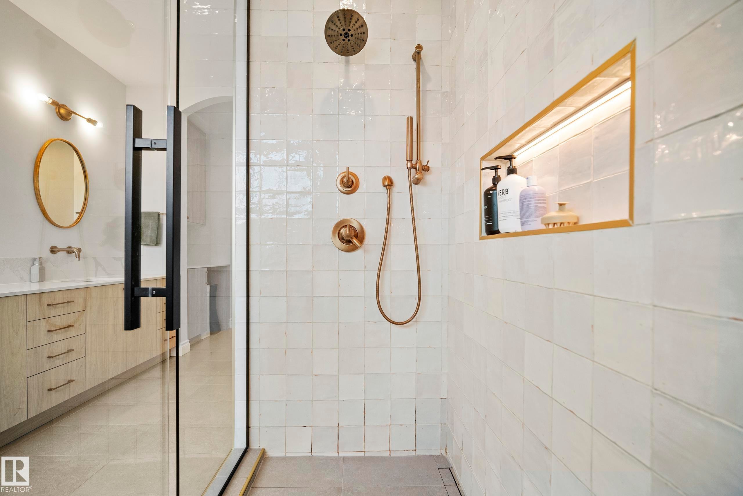 Walk-in shower featuring a glass enclosure with matte black hardware, white square tile, and brushed bronze fixtures - 6115 111 Avenue, Edmonton, AB - Indoor Photo Showing Bathroom