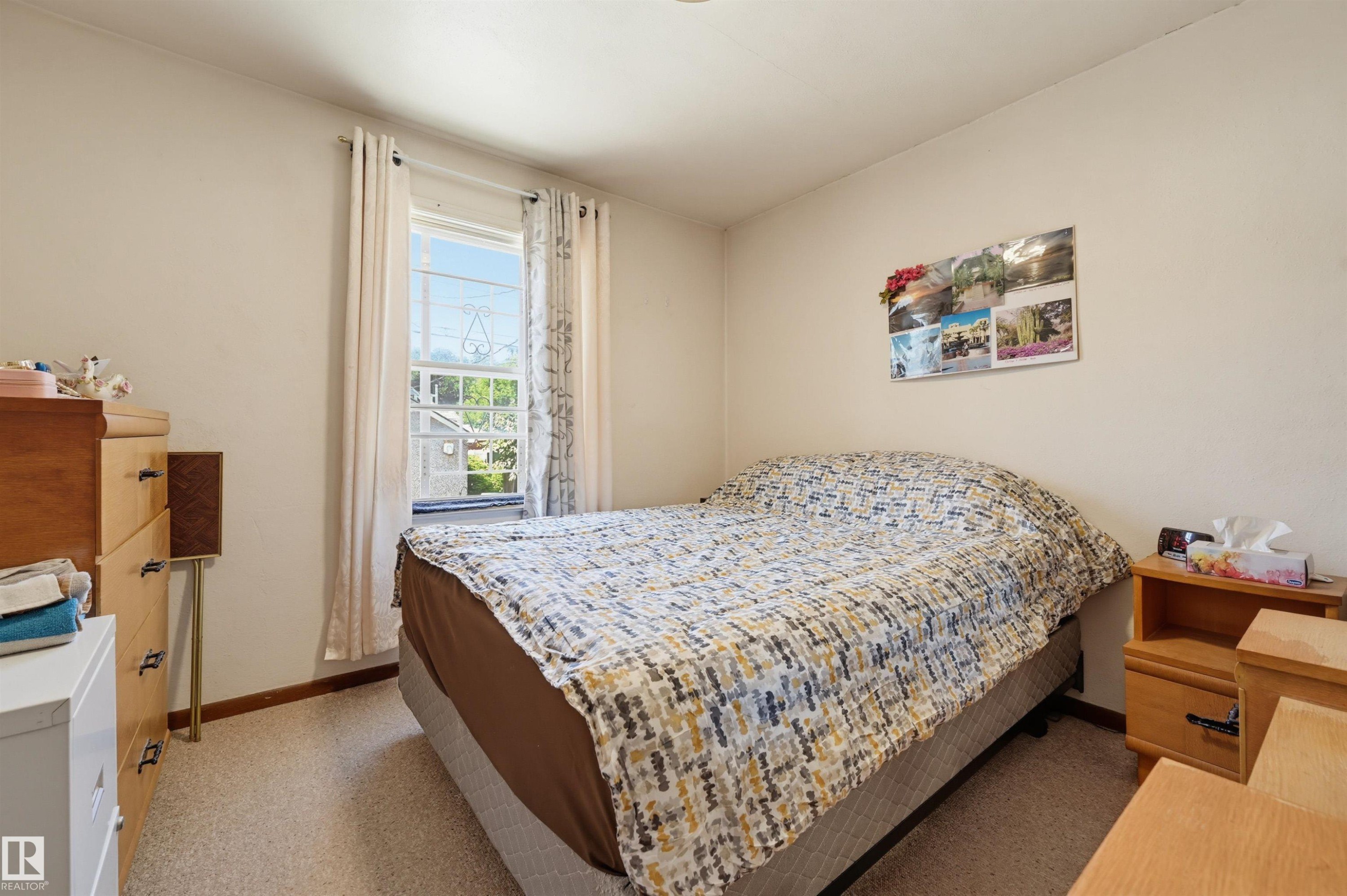 Bedroom featuring a window with natural light, neutral wall paint, and wall-to-wall carpeting - 11414 88 Street Nw, Edmonton, AB
