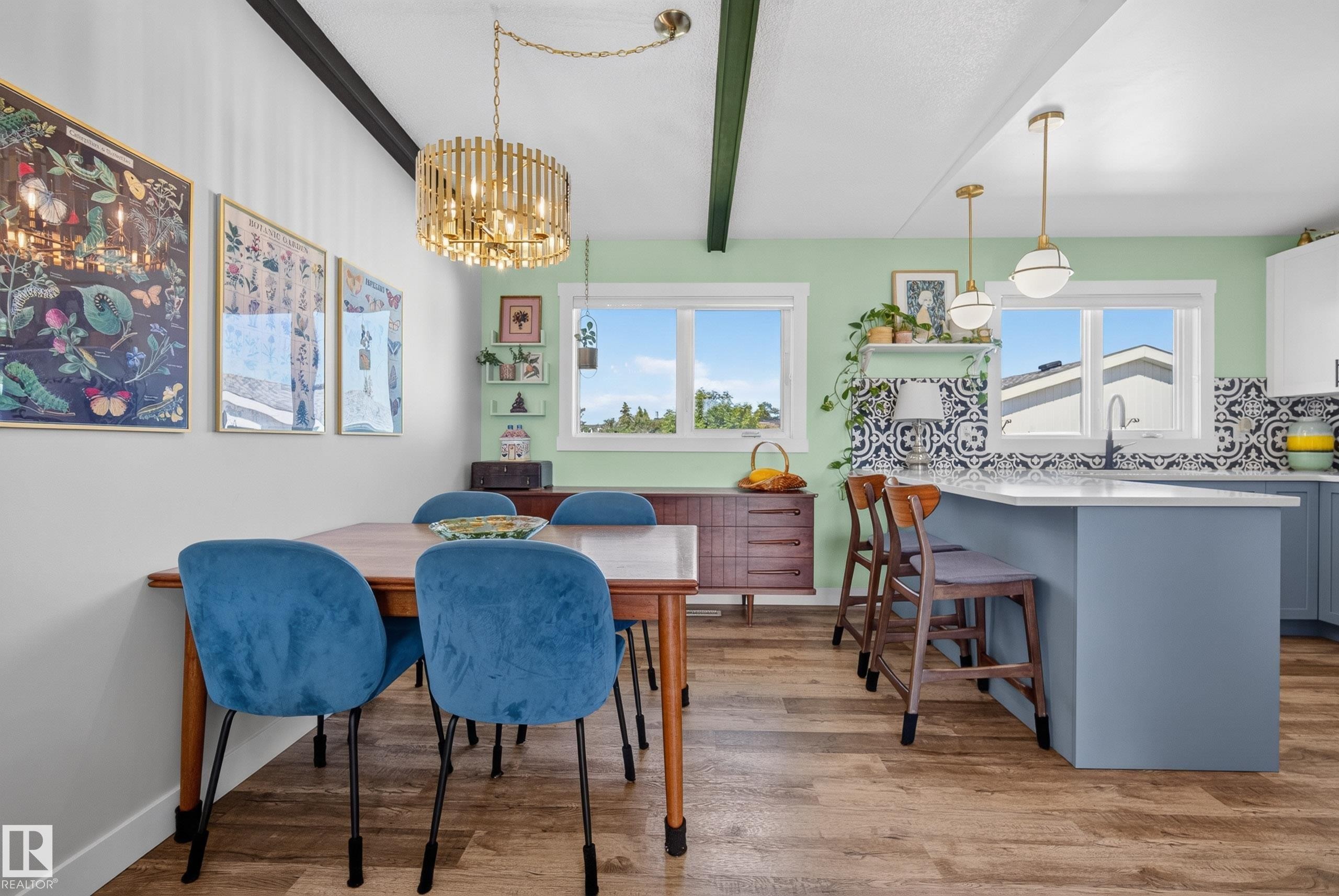Open-concept dining area and kitchen featuring wood-finish flooring - 14128 73 Street, Edmonton, AB