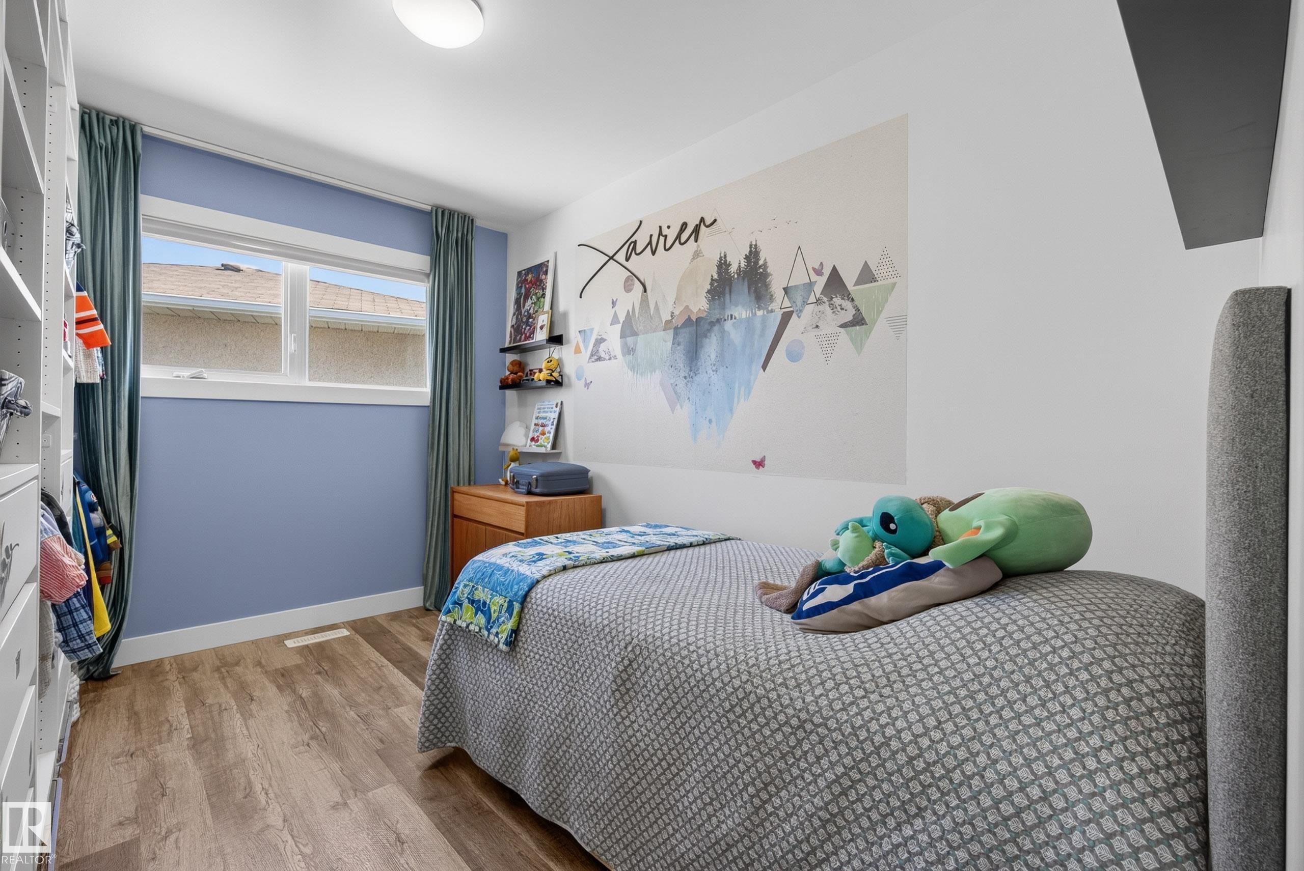 Wood-finish flooring throughout, featuring a double window with white trim, and a built-in closet system - 14128 73 Street, Edmonton, AB