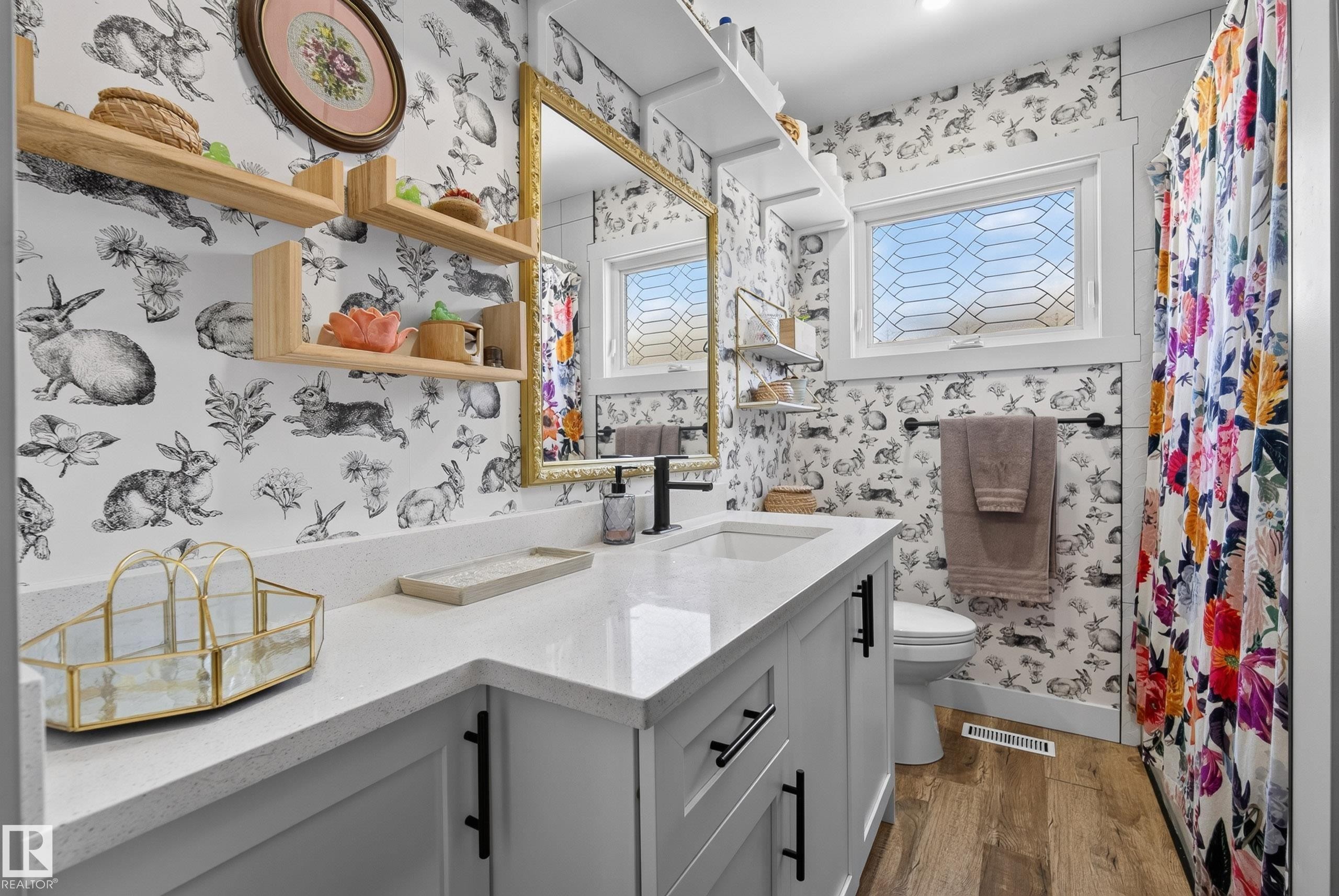 Bathroom featuring a white vanity with an integrated sink, a solid surface countertop, and matte black hardware - 14128 73 Street, Edmonton, AB