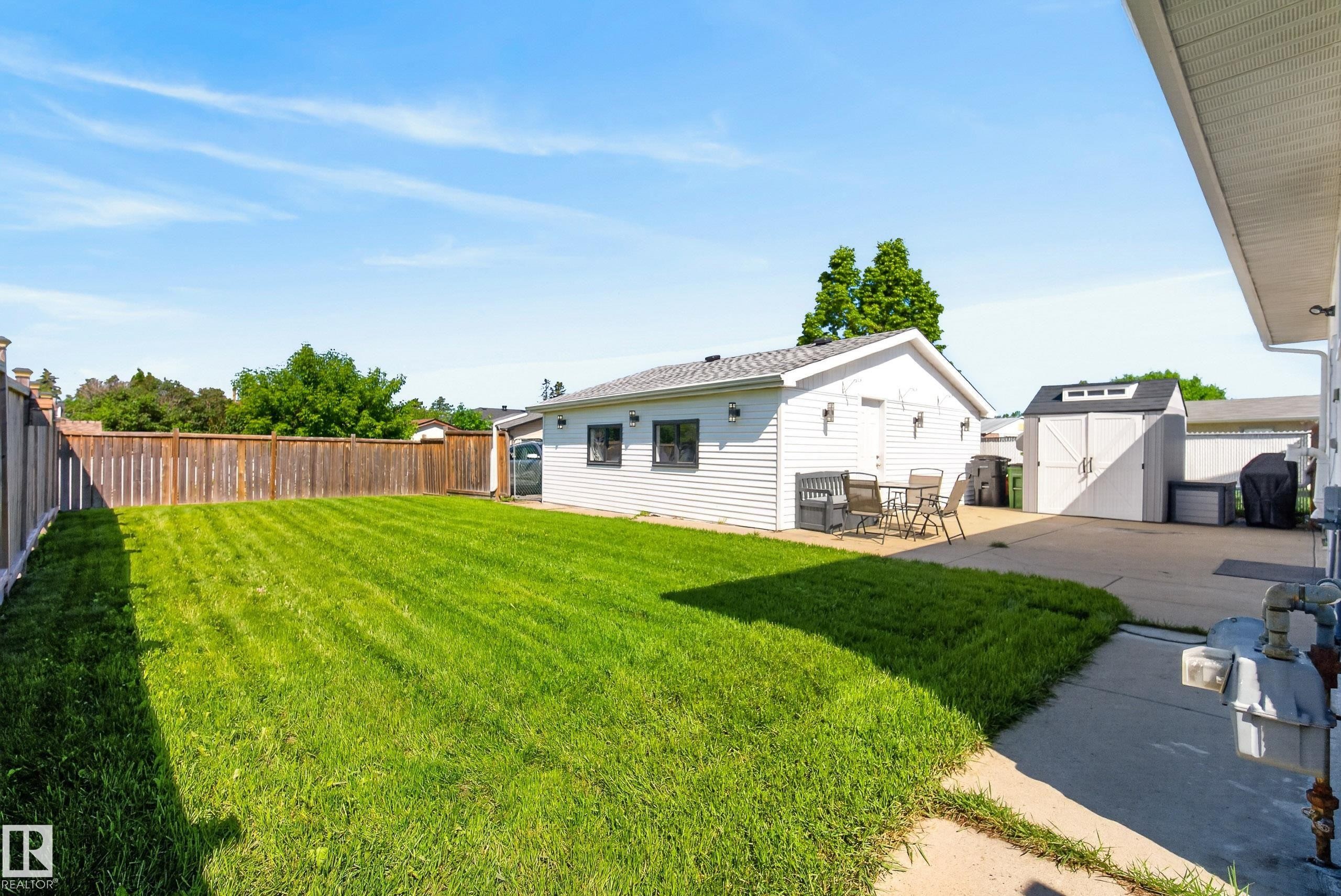 Expansive grassy yard with a wooden privacy fence - 14128 73 Street, Edmonton, AB