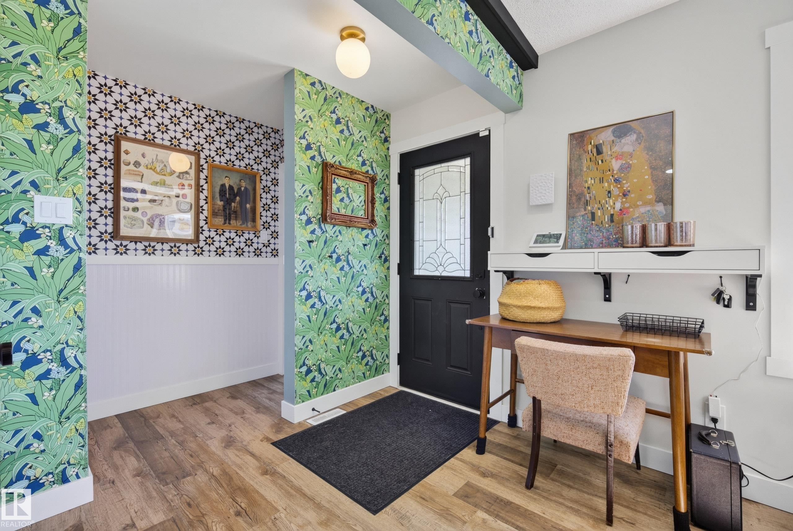Entryway featuring wood-finish flooring, a black front door with decorative glass, and a white mounted shelf with integrated drawers - 14128 73 Street, Edmonton, AB