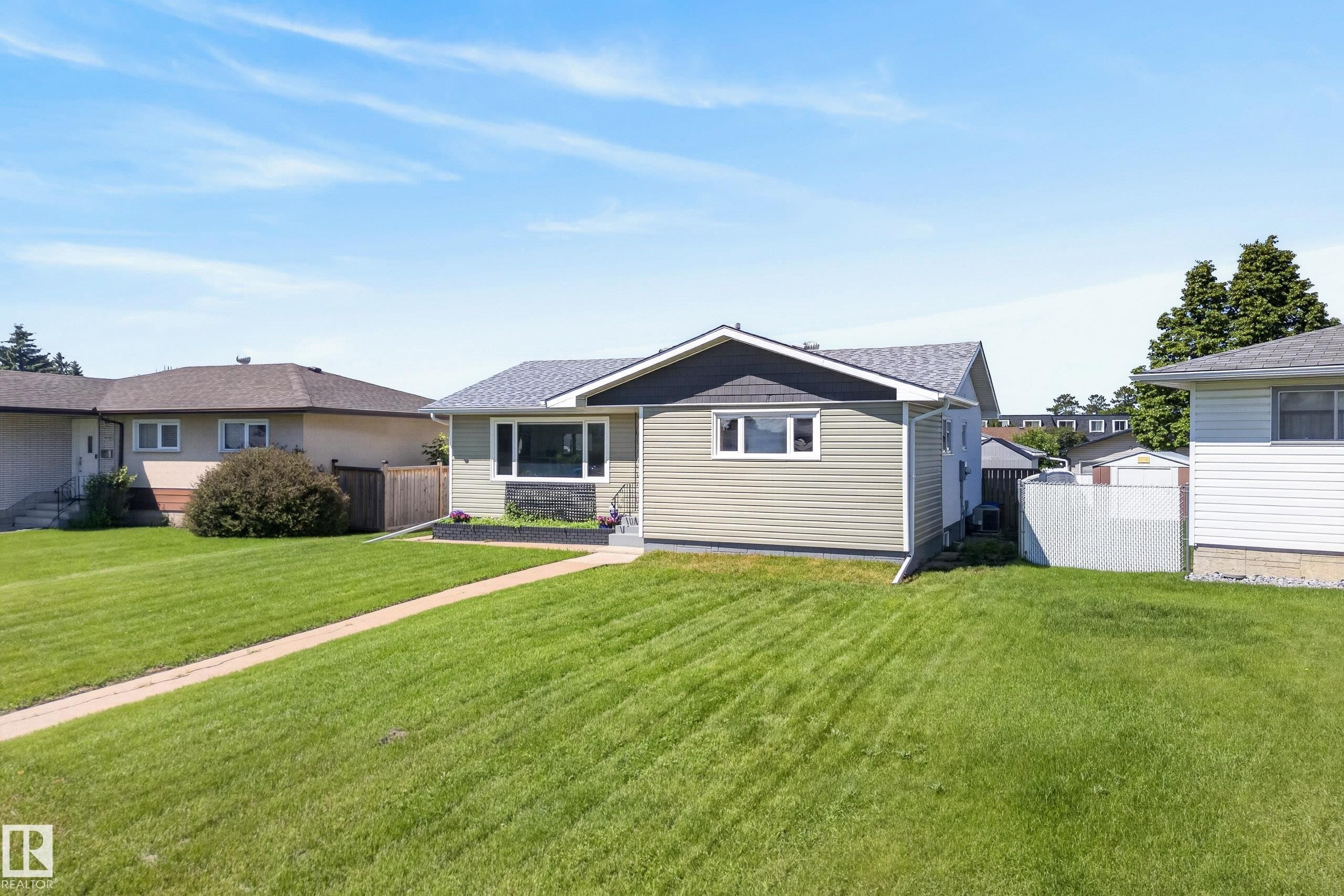 Exterior featuring light green horizontal siding and a dark gray shingle roof - 14128 73 Street, Edmonton, AB