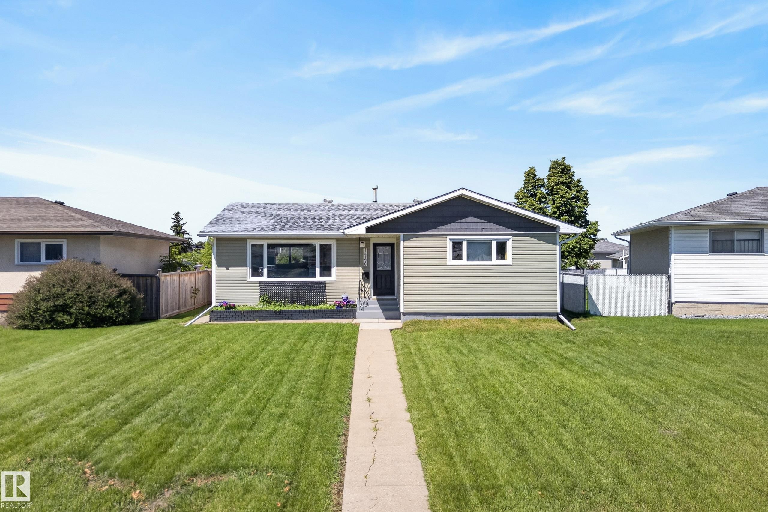Ranch-style residence featuring light green horizontal siding and dark gray trim - 14128 73 Street, Edmonton, AB