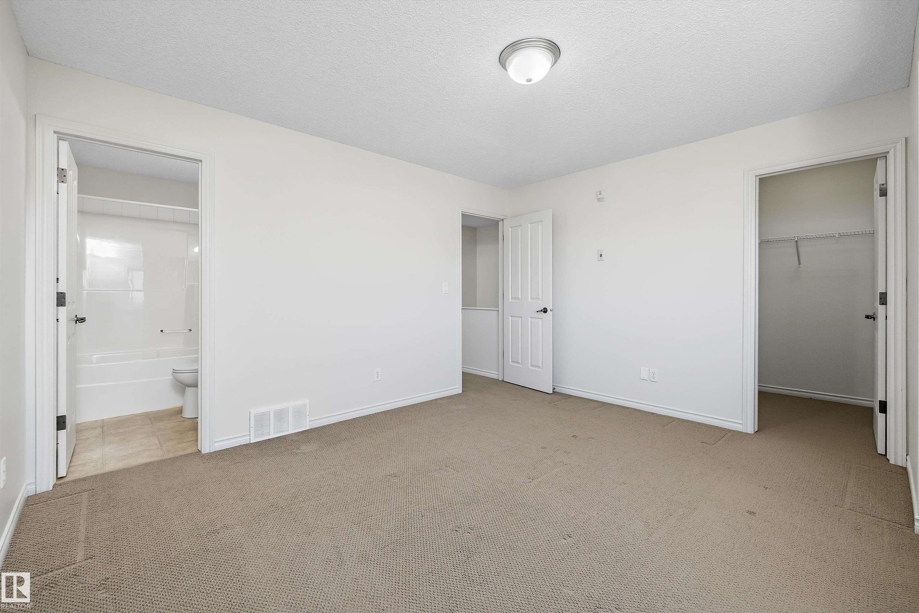 Carpeted room with white walls, a flush-mount ceiling light, and white baseboards - 101 13825 155 Avenue, Edmonton, AB