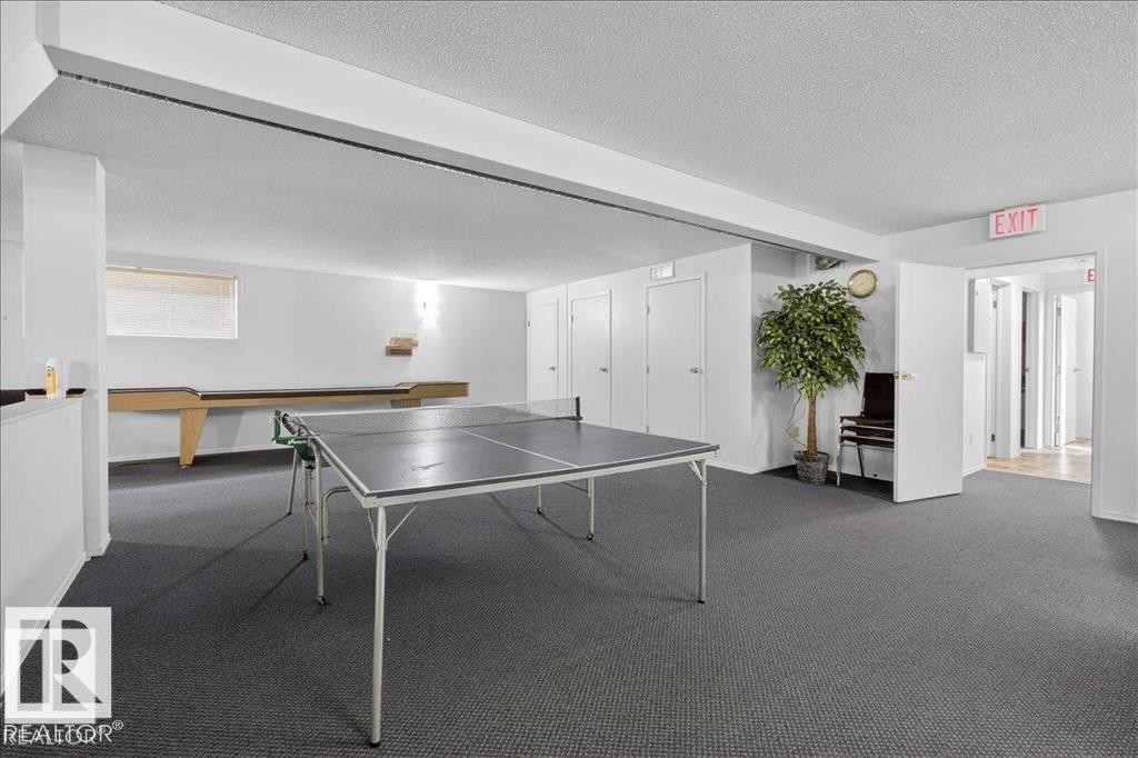 Spacious recreation room featuring dark gray carpeting and recessed lighting - 219 Knottwood Road, Edmonton, AB