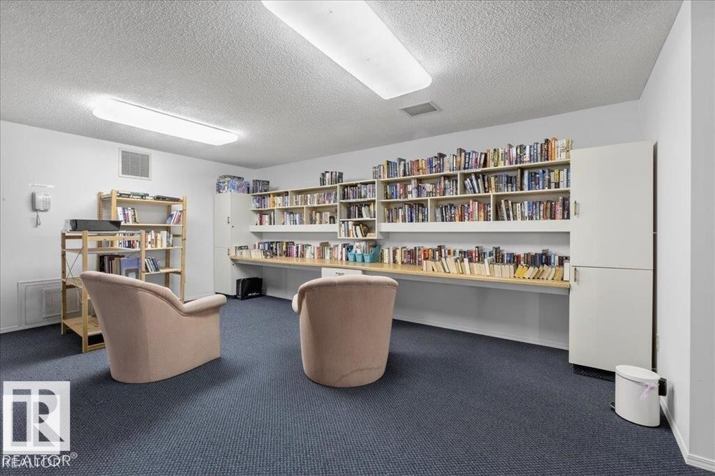 Room featuring extensive built-in shelving, a full-length countertop, and overhead fluorescent lighting - 219 Knottwood Road, Edmonton, AB