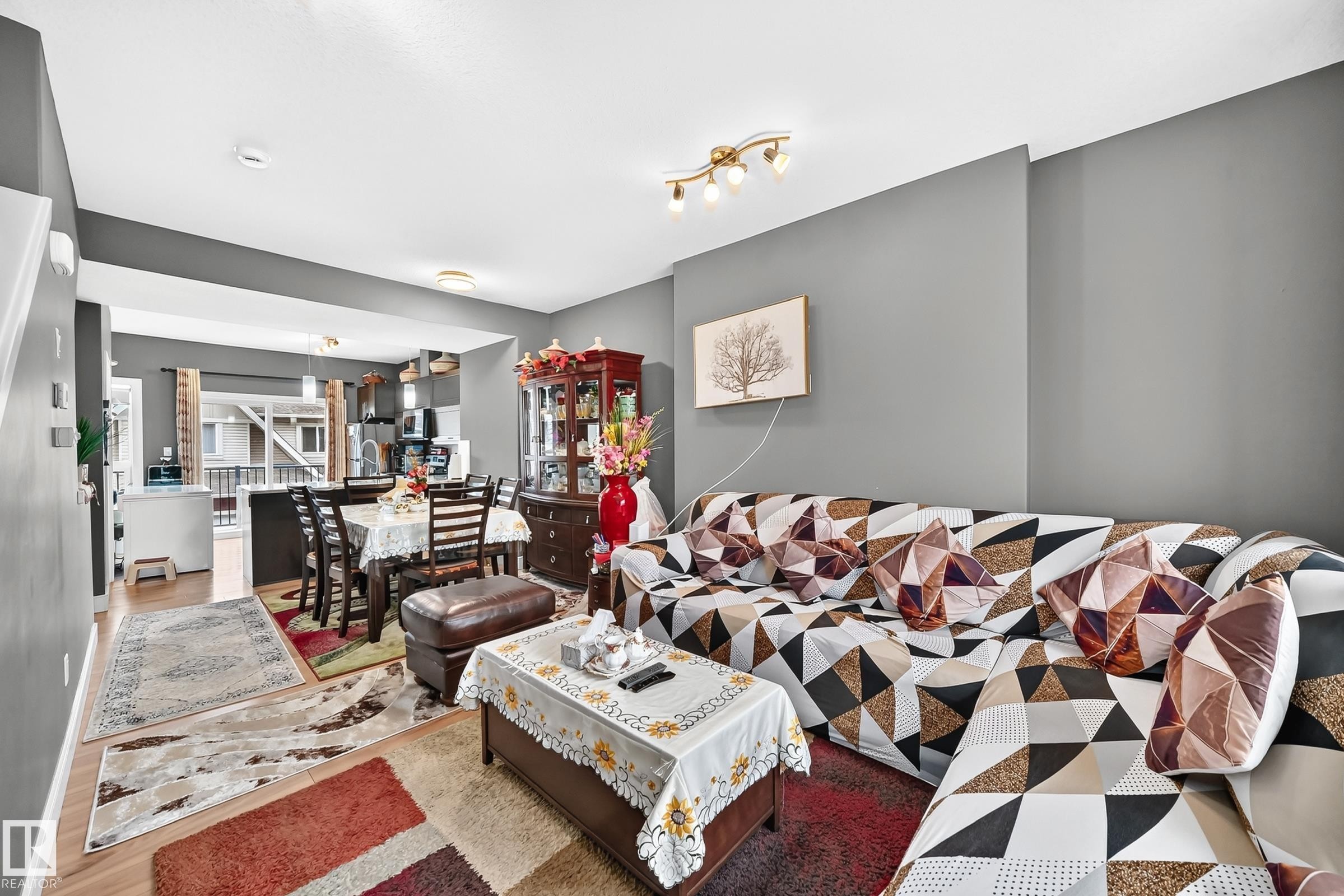 Expansive open-concept living area featuring wood-finish flooring, recessed lighting, and a neutral wall palette - 37 13003 132 Avenue Nw, Edmonton, AB
