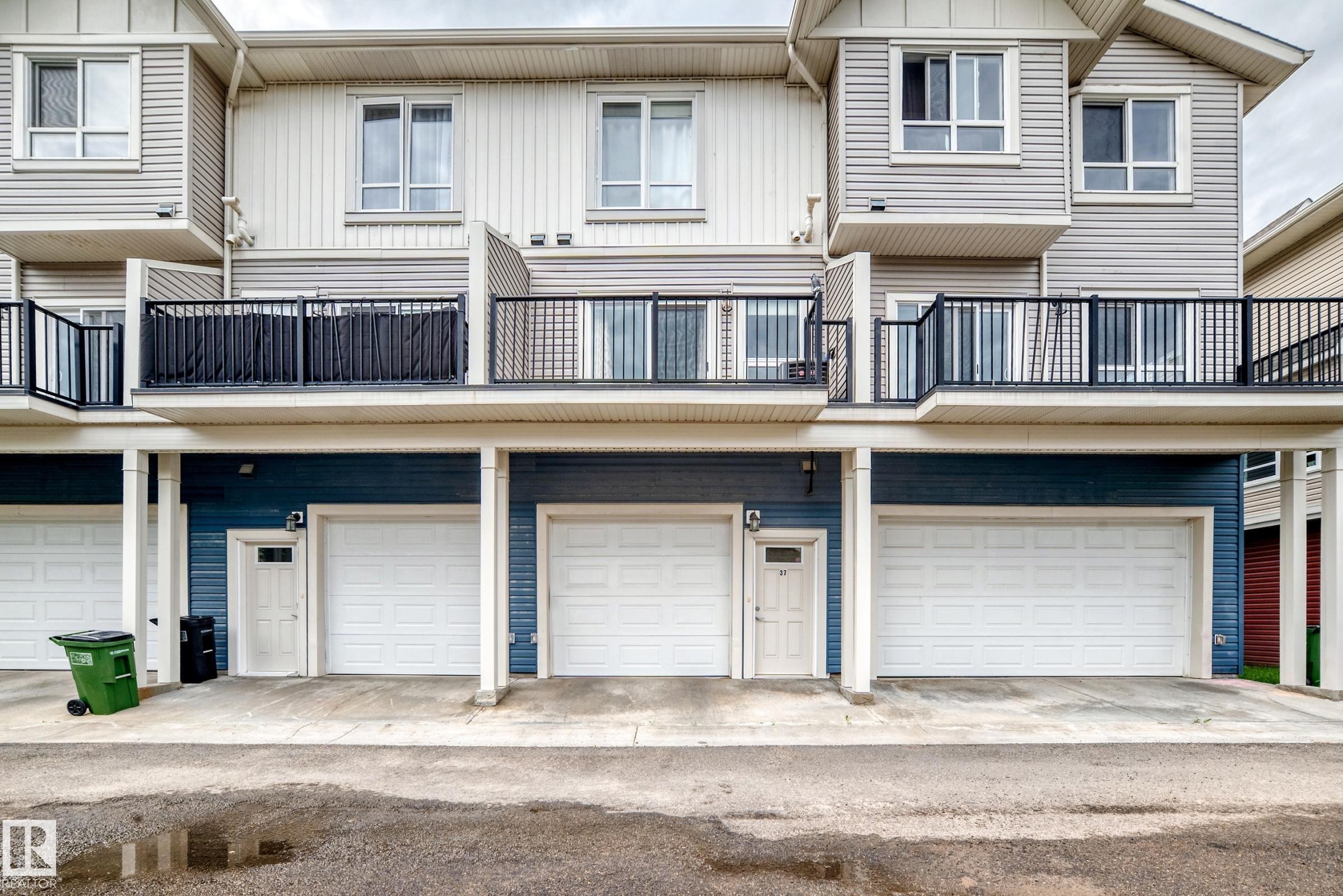 Multi-level exterior with light gray siding and dark blue lower level siding - 37 13003 132 Avenue Nw, Edmonton, AB
